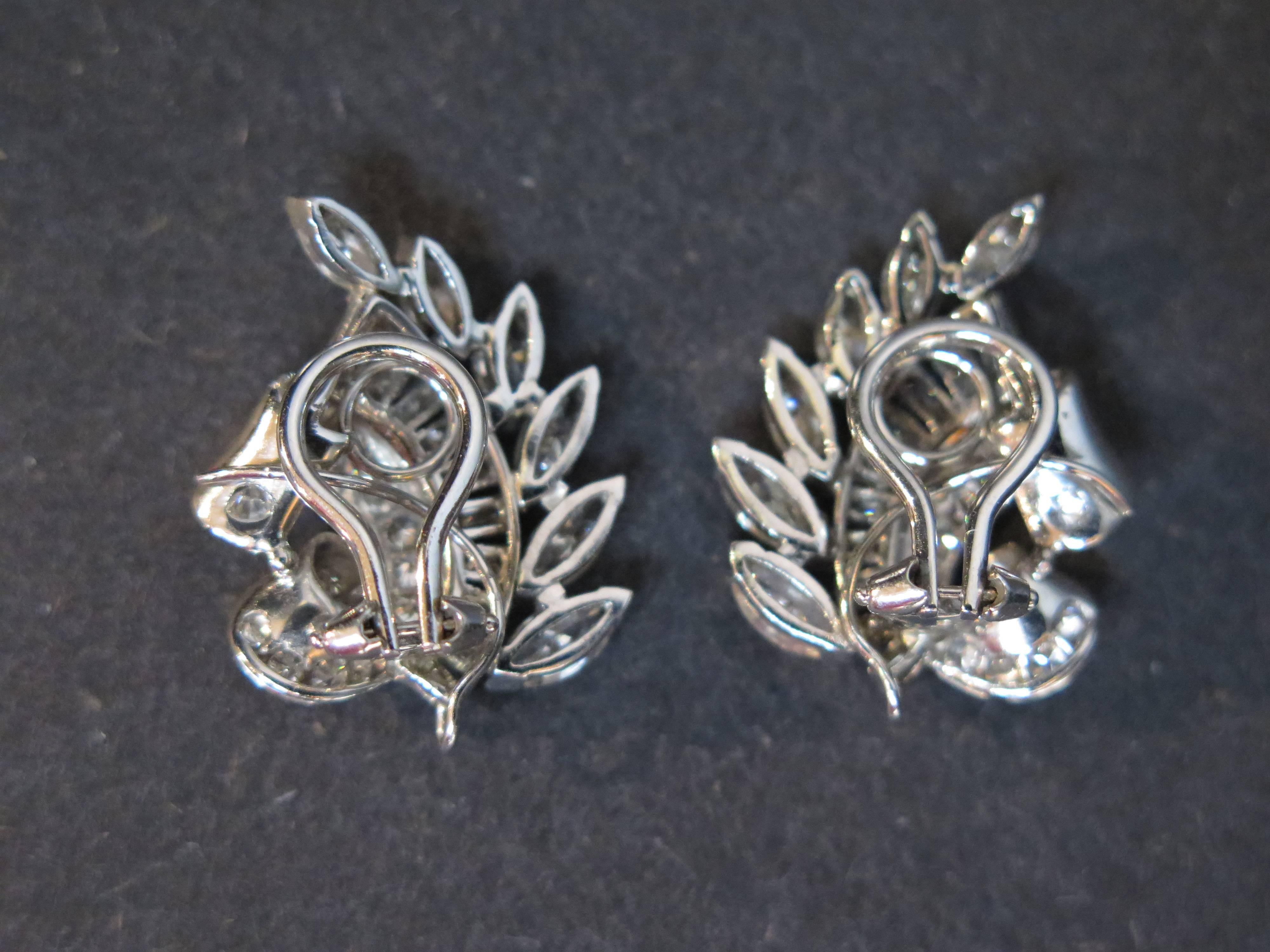 A wonderful and bright pair of elegant diamond and platinum ear clip earrings in a classic 1960's French style. 

The diamond clip earrings formed as swooping stylized wheat sheaves. 
A looped hook at the bottom of the earrings allows one to add