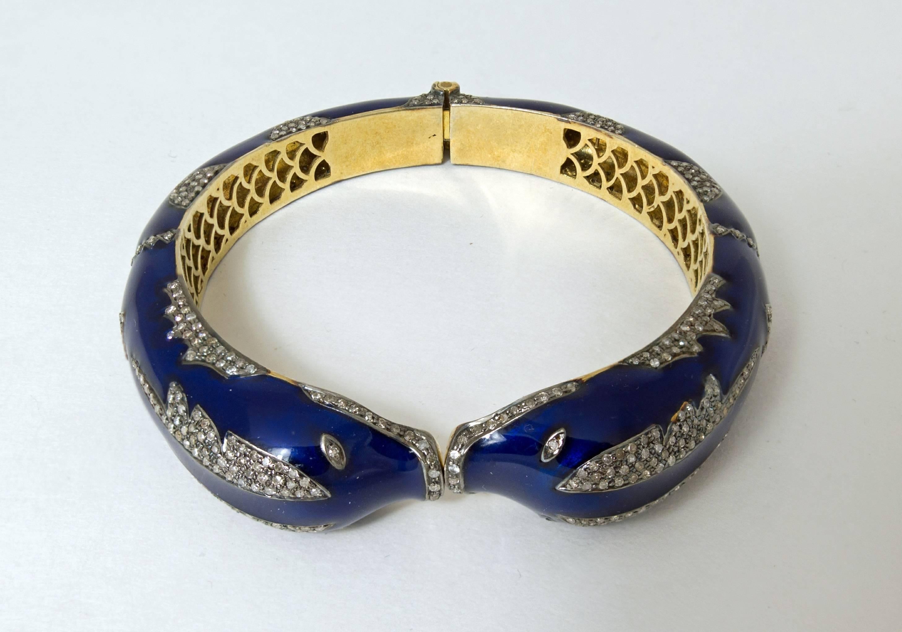 A fine, elegant  lady's hinged bangle bracelet with kissing dolphin design. Crafted in 18 k yellow gold, blue enamel with 544 single cut diamonds, bead set, totaling 4.08 carats. Made in Russia in 1950's. Interior diameter 58 mm x 53 mm, outer