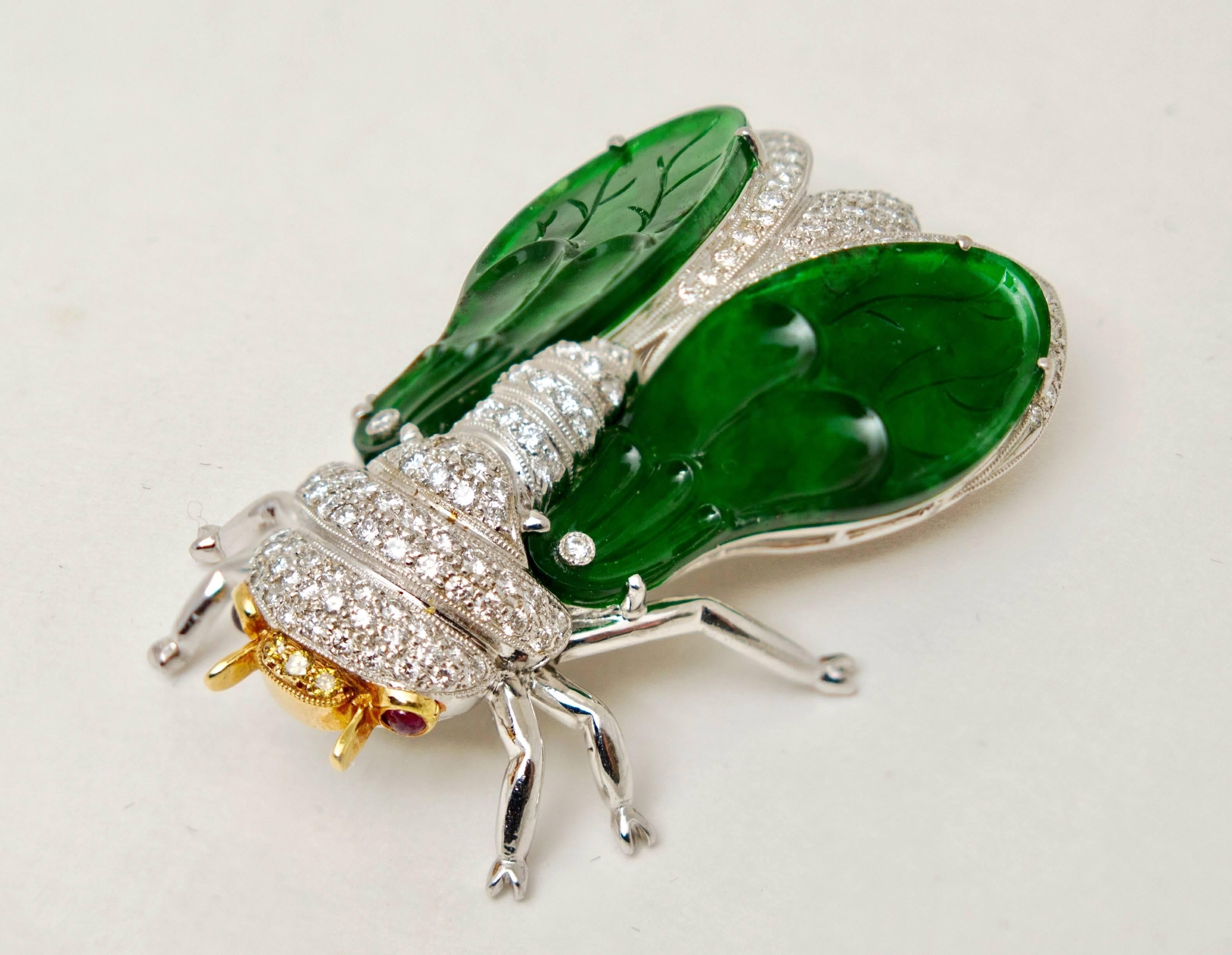 An adorable brooch or pendant in a form of cicada. Crafted of 18 K white and yellow gold with 2 carved natural type ” A”  jadeite plaques as wings, pave set colorless and yellow diamonds on body, and ruby set eyes. 
Jadeite plaques measured 30.90 x