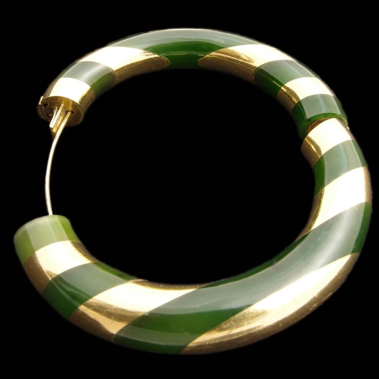 An iconic and elegant 18K gold and green jade bangle by Angela Cummings for Tiffany, circa 1985. 
Signed T&CO. 

Approx. outside diameter: 3.3