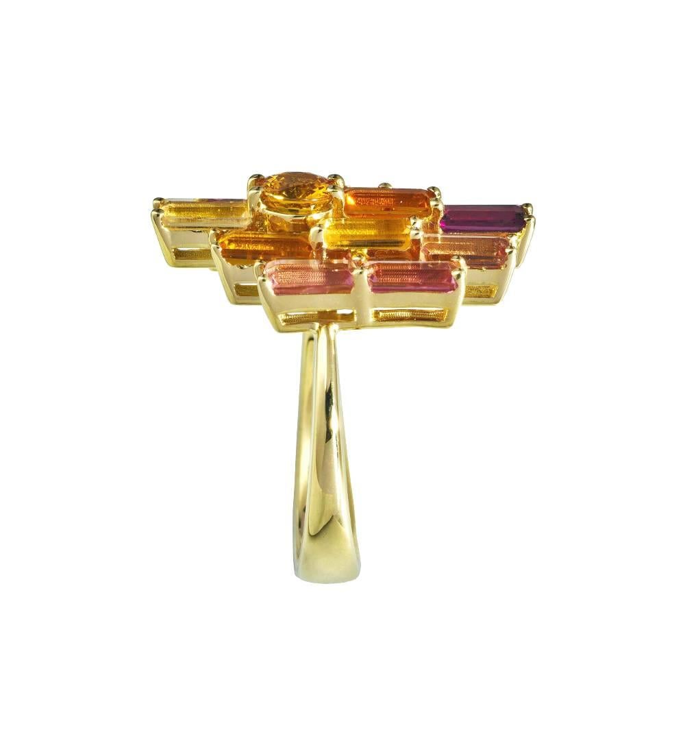 A large impressionist style cocktail ring by Daou in a fusion of orange yellows, pink and purple gemstones set in such a way at different heights to let light in and diffract all the colours within. These graduated hand selected jewels are set in