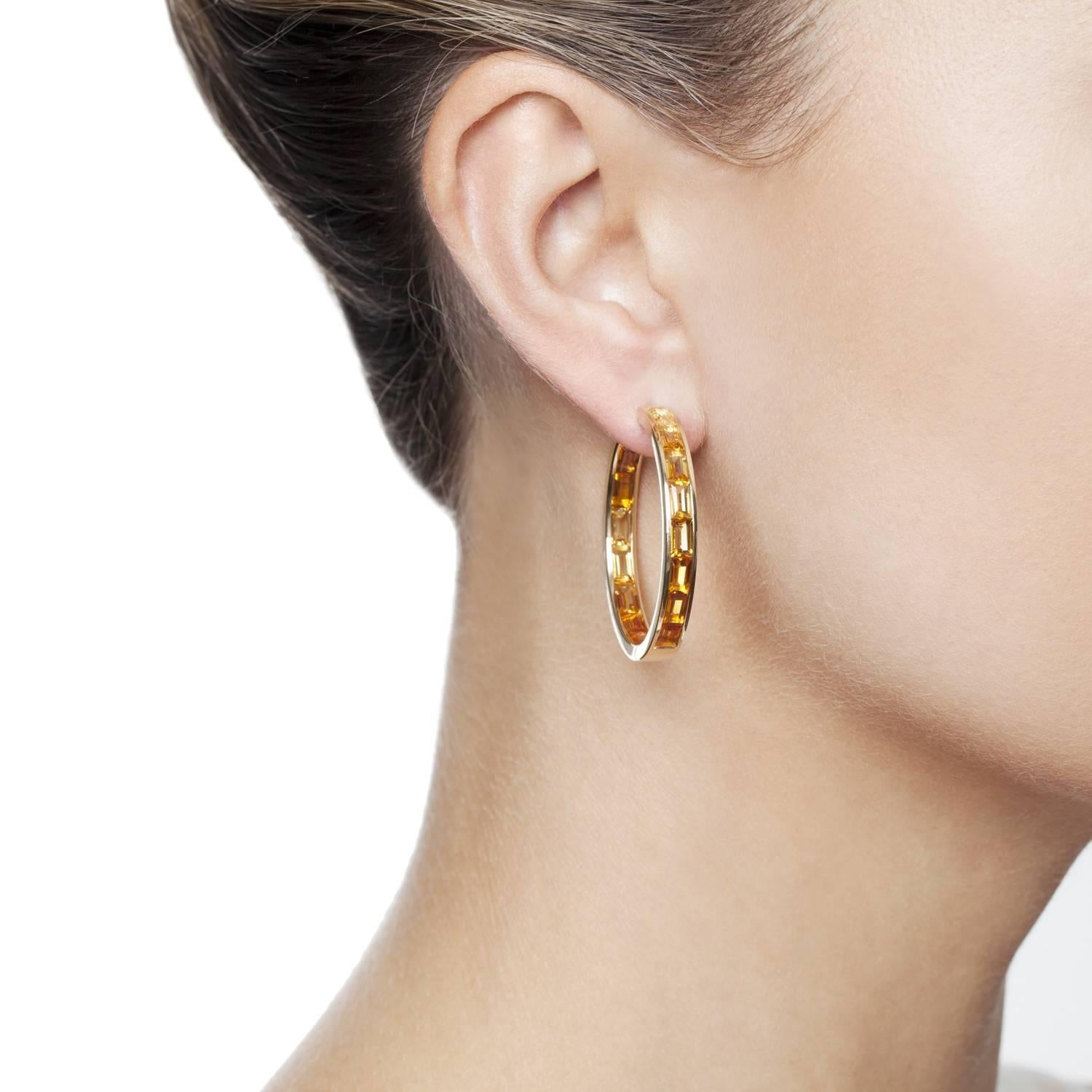 Gold graduated baguette gemstones in the Daou hoop earring is heightened by the perfect setting to allow light to refract through creating flashes of beautiful colour, glowing like a stained glass window. The fine setting extends to the back of the