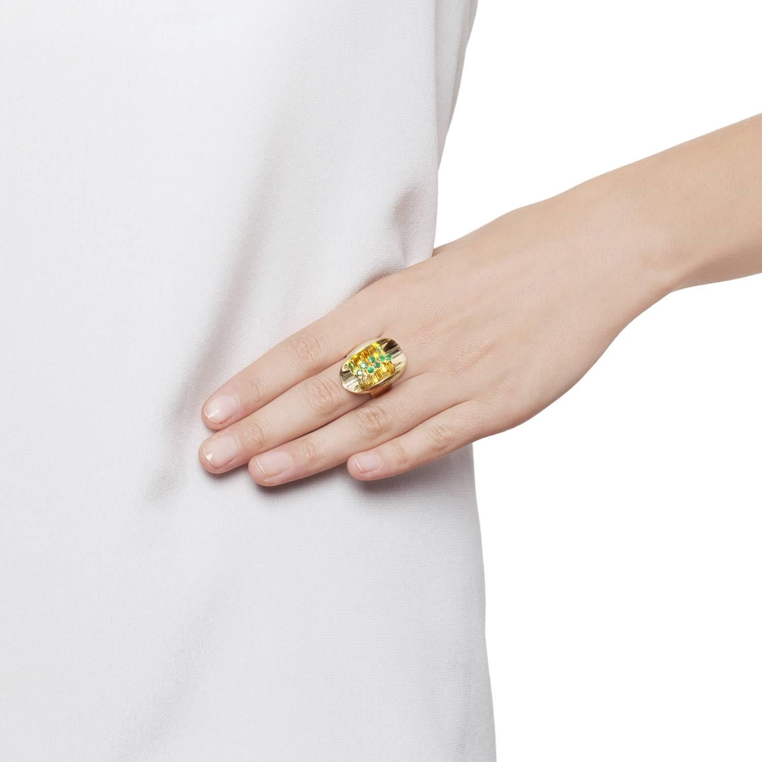 An Emerald set complex handmade Yellow Gold Ring. A striking miniature sculpture, the Ellipse rings feature concave forms creating depth and myriad reflections of the delicately set gemstones within. From every view there is an additional detail and