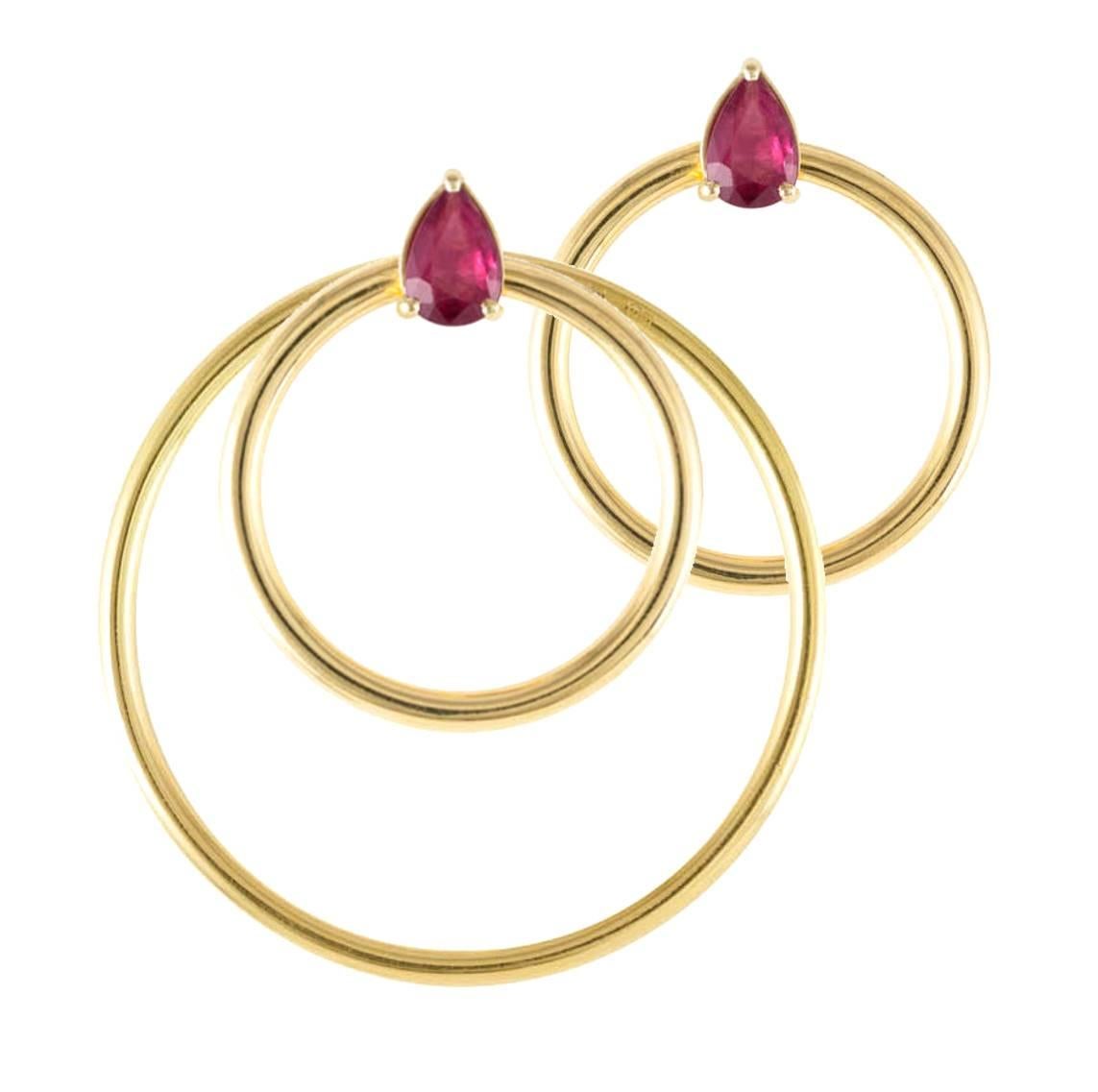 Ruby and yellow gold small front facing hoop earrings. Simple chic earrings set with pear cut rubies in yellow gold. Perfectly geometrically balanced to be pleasingly elegant and flattering. A perfect complement to the Quanta collection and