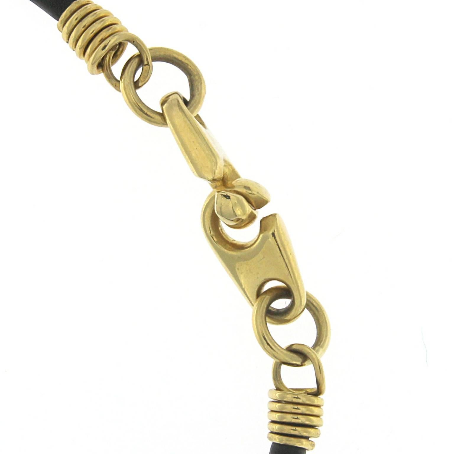 Rubber cord with lobster clasp in yellow gold 
Marine closure  in 18kt gold,  weight gr 7.60
Stamp: 750