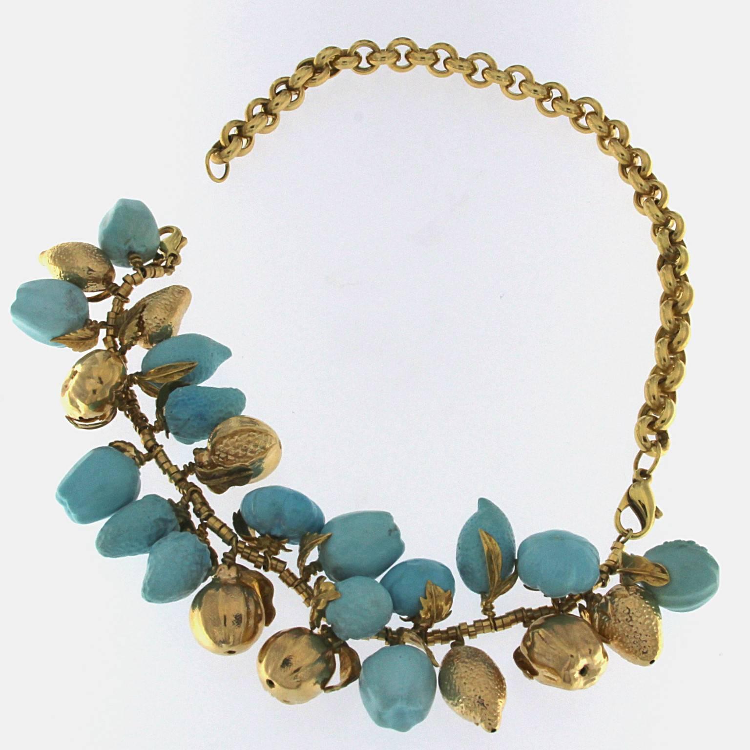 Turquoise and 18kt yellow gold fruit necklace
The front part can be worn as a bracelet taking out the back since it has 2 clasps. 
Total weight of 18 kt gold: gr 59.60
Total weight of red coral: gr 36,10
Stamp: 10 MI, 750, ITALY