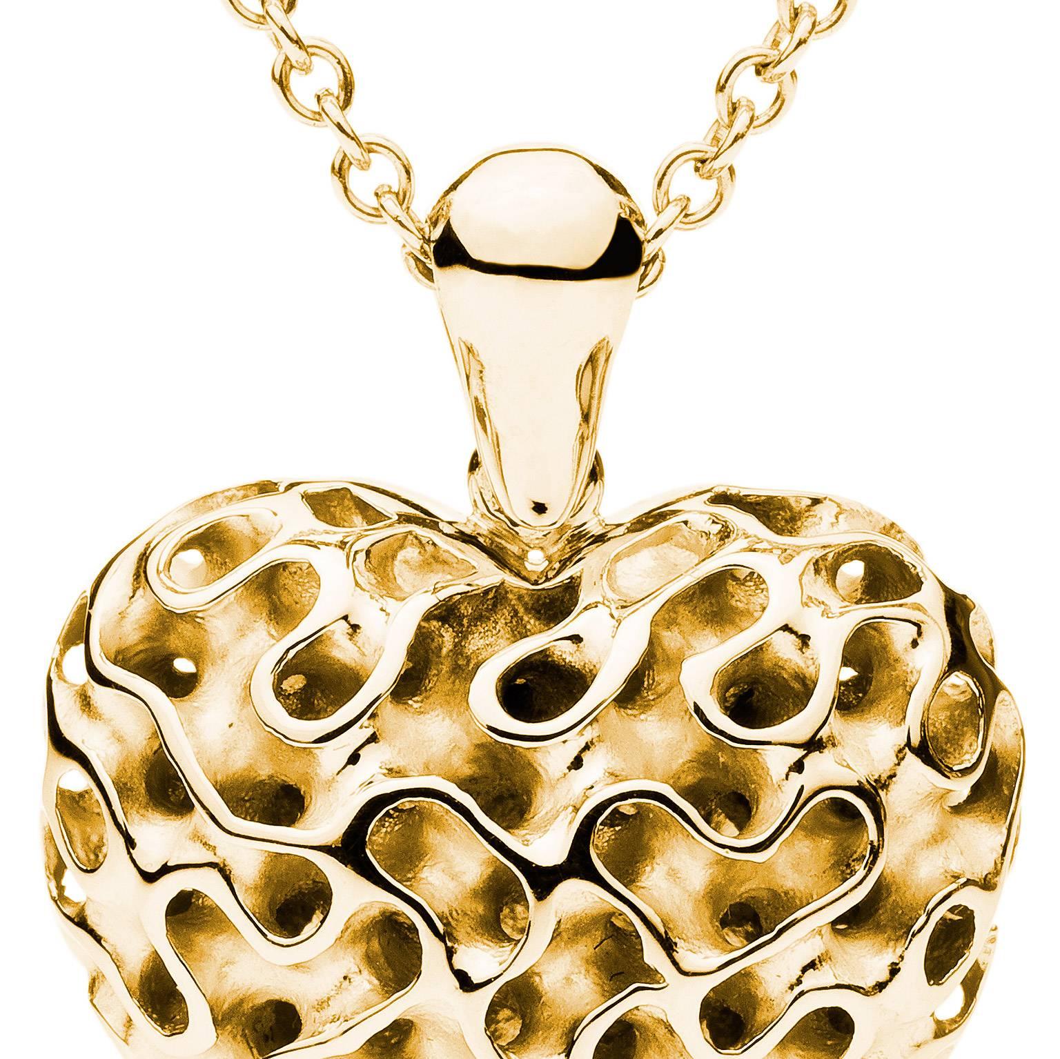 This lovely 18 Karat yellow gold heart pendant designed by Towe Norlen in 2009, is shaped as a perfectly curved heart with a prominently rounded body. It is built up from the characteristic open-work Towe Silk pattern. The winding Silk pattern