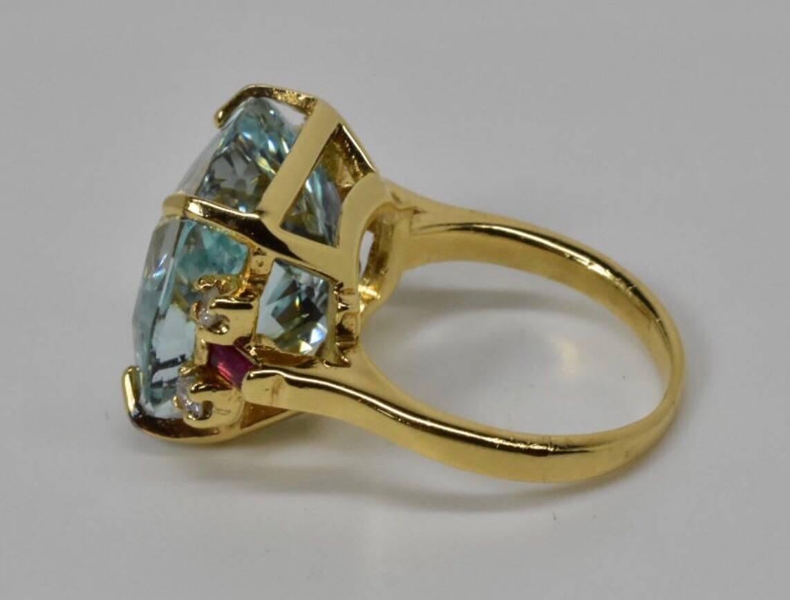 An Aquamarine diamond and ruby vintage ring set in14k yellow gold. The ring feature a large central aquamarine with a baguette cut ruby and two brilliant cut diamonds set to each shoulder.
Measurements: ring top is 14mm x 19mm.
Size: UK K EU 50