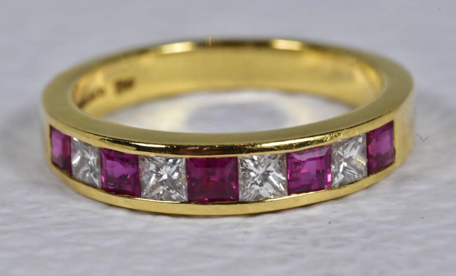 A Tiffany & Co Diamond and Ruby Eternity ring set in 18k yellow gold. The ring features five rubies and four diamonds in  princess cut set to a plain yellow gold band. 
Ring size - UK L 1/2 US 5.5 EU 51.3/4
Measurements: 3.7 mm at widest point