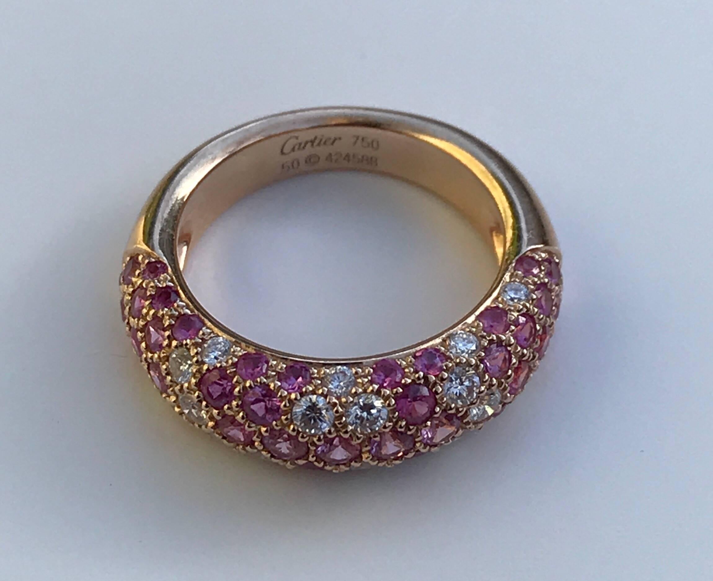 A Cartier Etincelle De Cartier diamond and pink sapphire ring set in18k rose gold. The ring feature brilliant cut natural pink sapphires and diamonds in a pave setting to a plain rose gold band.
The ring is sold with box but does not have