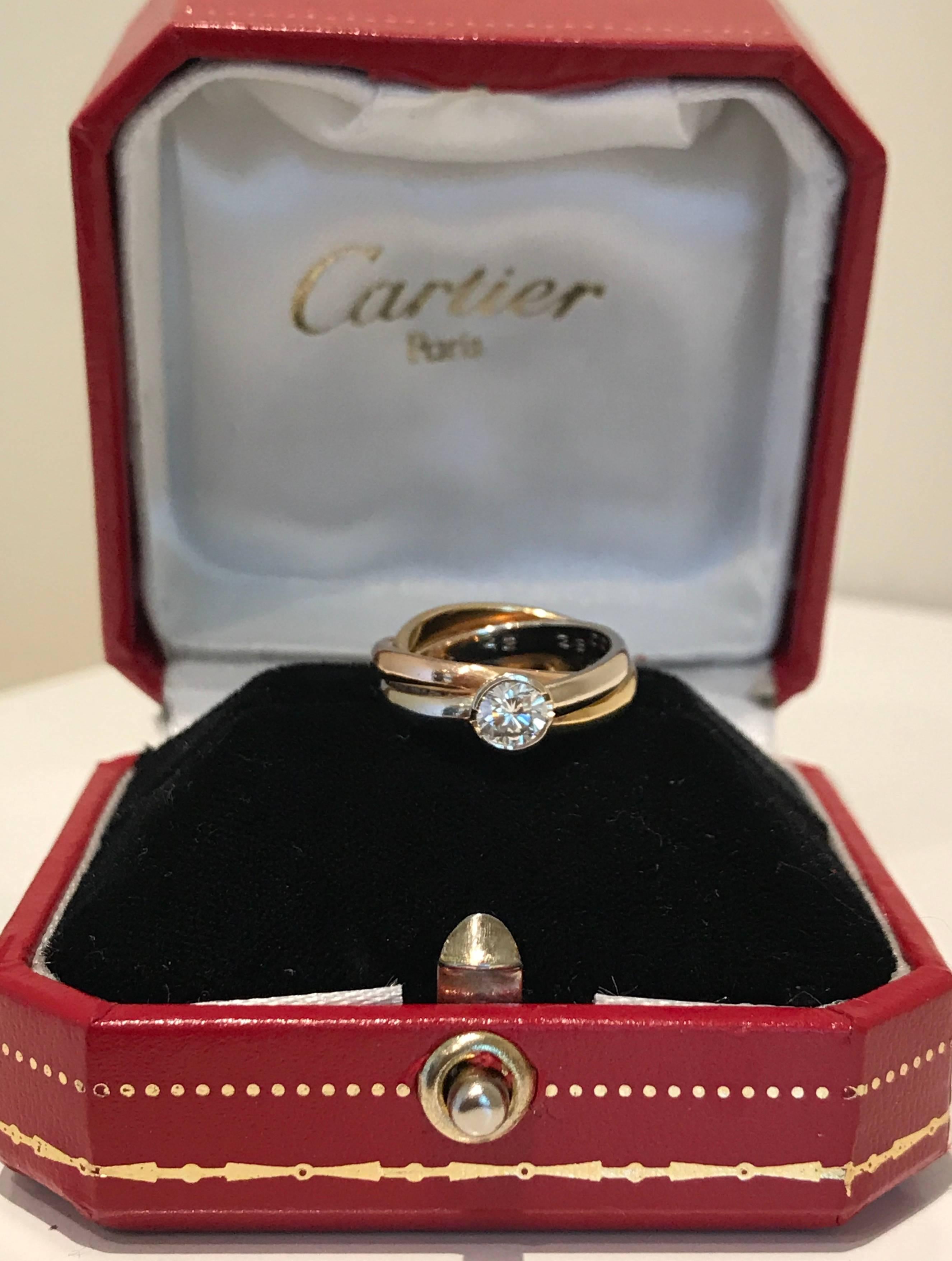 A Cartier tri-colour diamond solitaire diamond ring set in 18k gold. The ring features a tri-coloured rolling ring has white, yellow and rose gold bands interlocking and features a brilliant cut round diamond of approx 0.50 carat in weight.