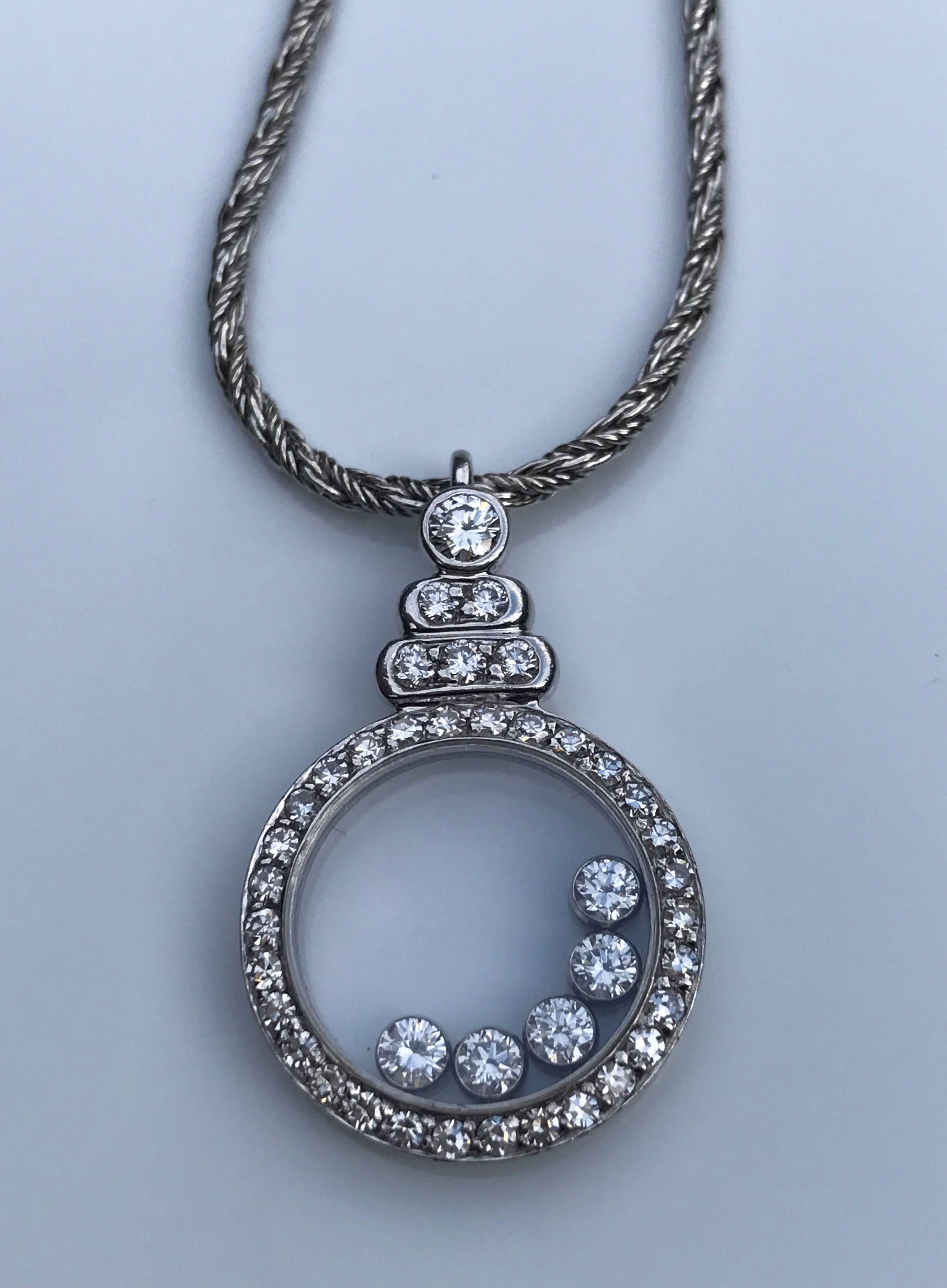 A 1980's Chopard 'Happy Diamonds' corded necklace set in 18k white gold. The necklace features a circular pendant with five free moving brilliant-cut round diamonds with an additional thirty-six diamonds set to the pendant edge and above the