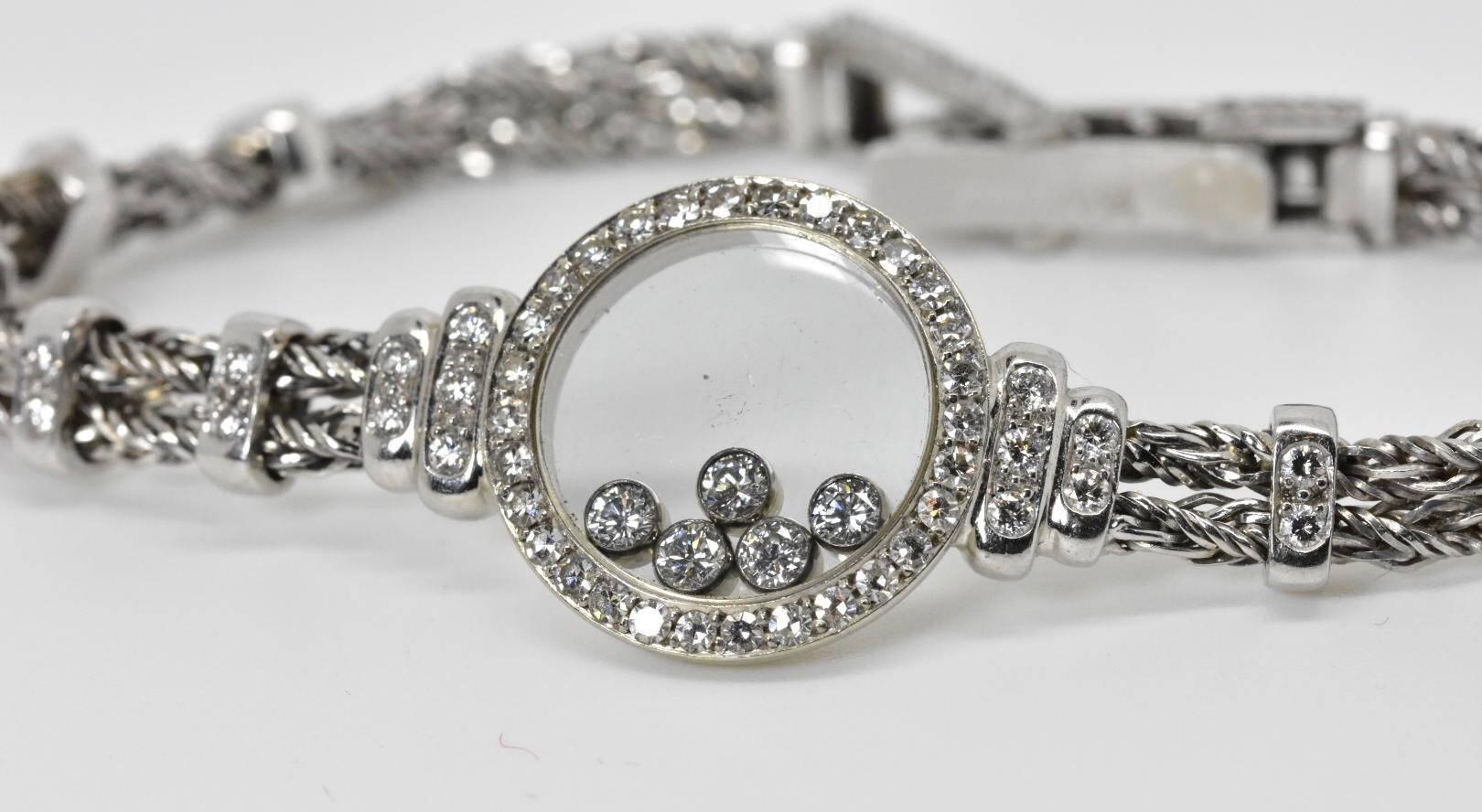 1980's Chopard 'Happy Diamonds' Pendant bracelet set to a two strand 18k white gold. The bracelet features a circular sapphire glass pendant with five free moving brilliant-cut round diamonds of approx .25 carats. The bracelet also has an additional