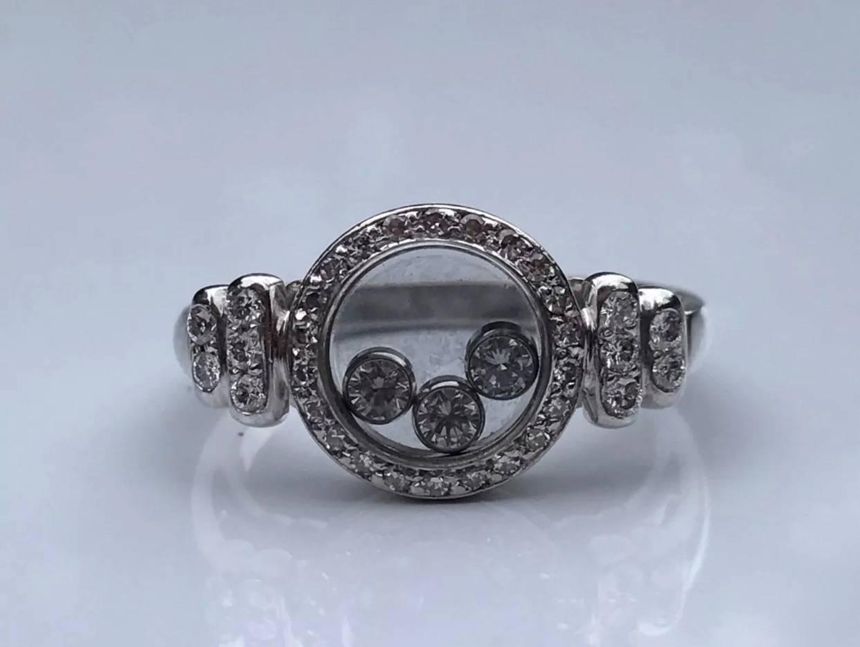 A vintage Chopard 'Happy Diamonds' ring set in 18k white gold. The ring features three free moving brilliant-cut diamonds in a double round sapphire glass setting with diamond shoulders and case.
Size : UK M EU 52
Weight: 5.4
Ring head measurement: