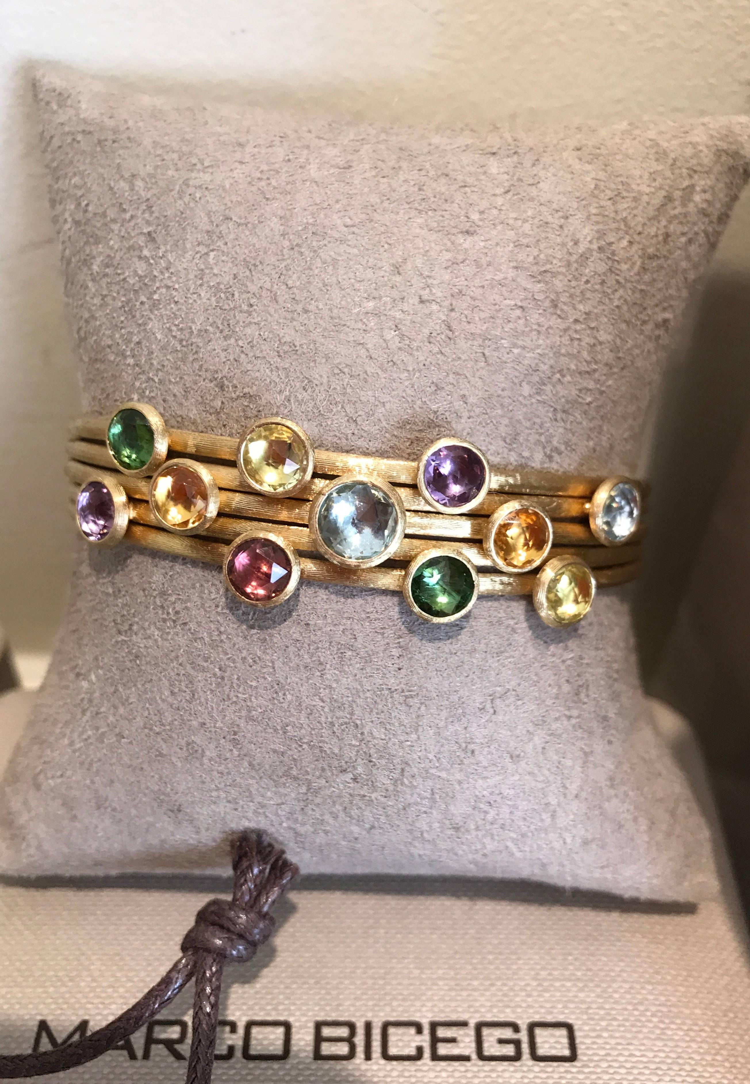 A Marco Bicego Jaipur five strand mixed stone cuff set in 18k yellow gold. The Jaipur bracelet features mixed semi precious gemstones mixed tourmaline; mixed quartz; beryl and garnet set to a hand engraved cuff. 
Retail price £3977
Measurements: