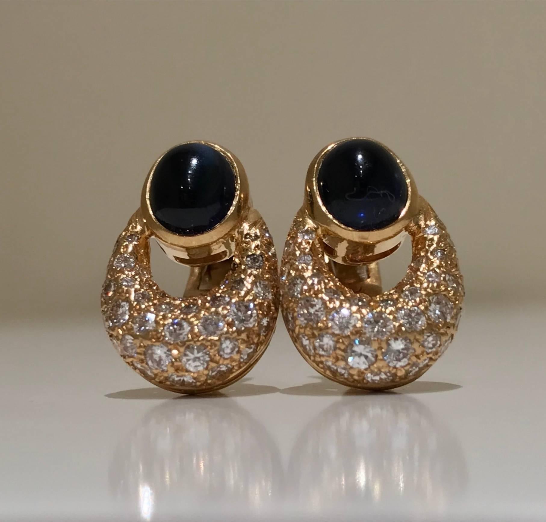 
A pair of sapphire and diamond earrings  by Cartier set in 18k yellow gold. Each earring features a cabochon sapphire in a rub over setting of pave set brilliant cut diamond hoops
Diamond weight: approximately 0.70 carats total
Sapphires: approx