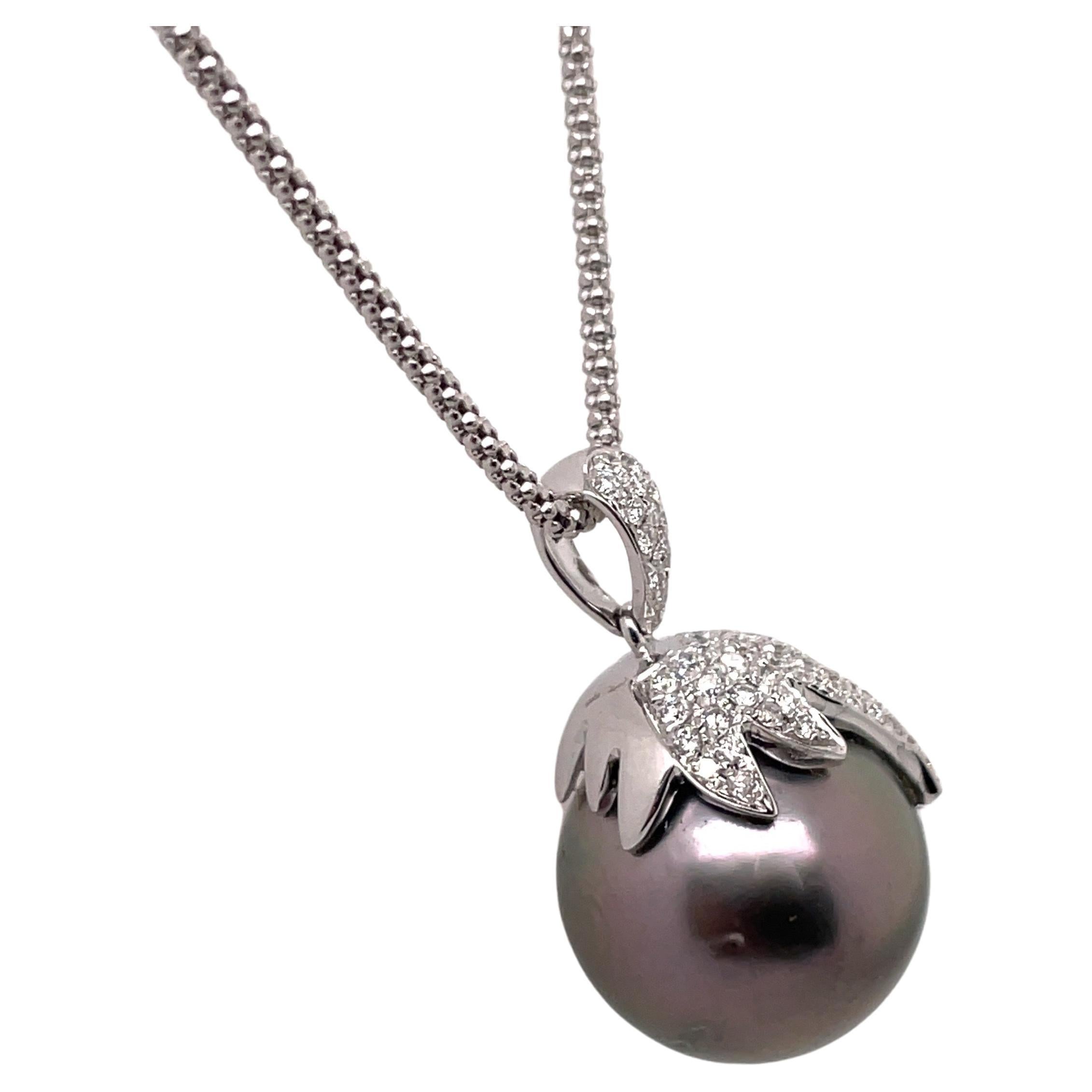 18 Karat white gold pendant featuring one grey Tahitian Pearl measuring 15 mm with a diamond cap of 86 round brilliants weighing 0.83 carats. 

Diamond Bale 8.4 MM Long
Diamond Cap with Pearl measures 18.9 MM Long
Pedant total 27.3 MM Long

Color