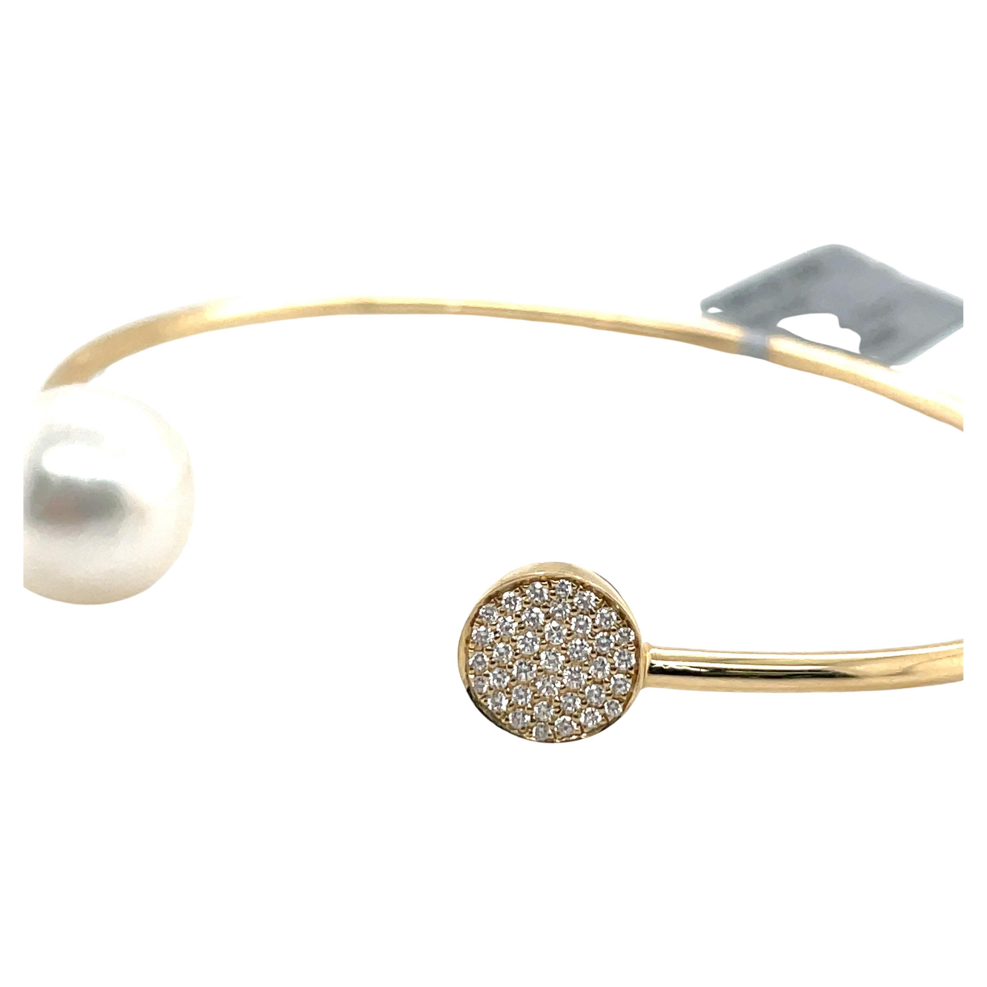 Bracelet manchette ouvert en or jaune 14 carats avec 37 brillants ronds pesant 0.13 carats et une perle des mers du Sud mesurant 11-12 MM.
Livré en or blanc et peut personnaliser la couleur de la perle. 