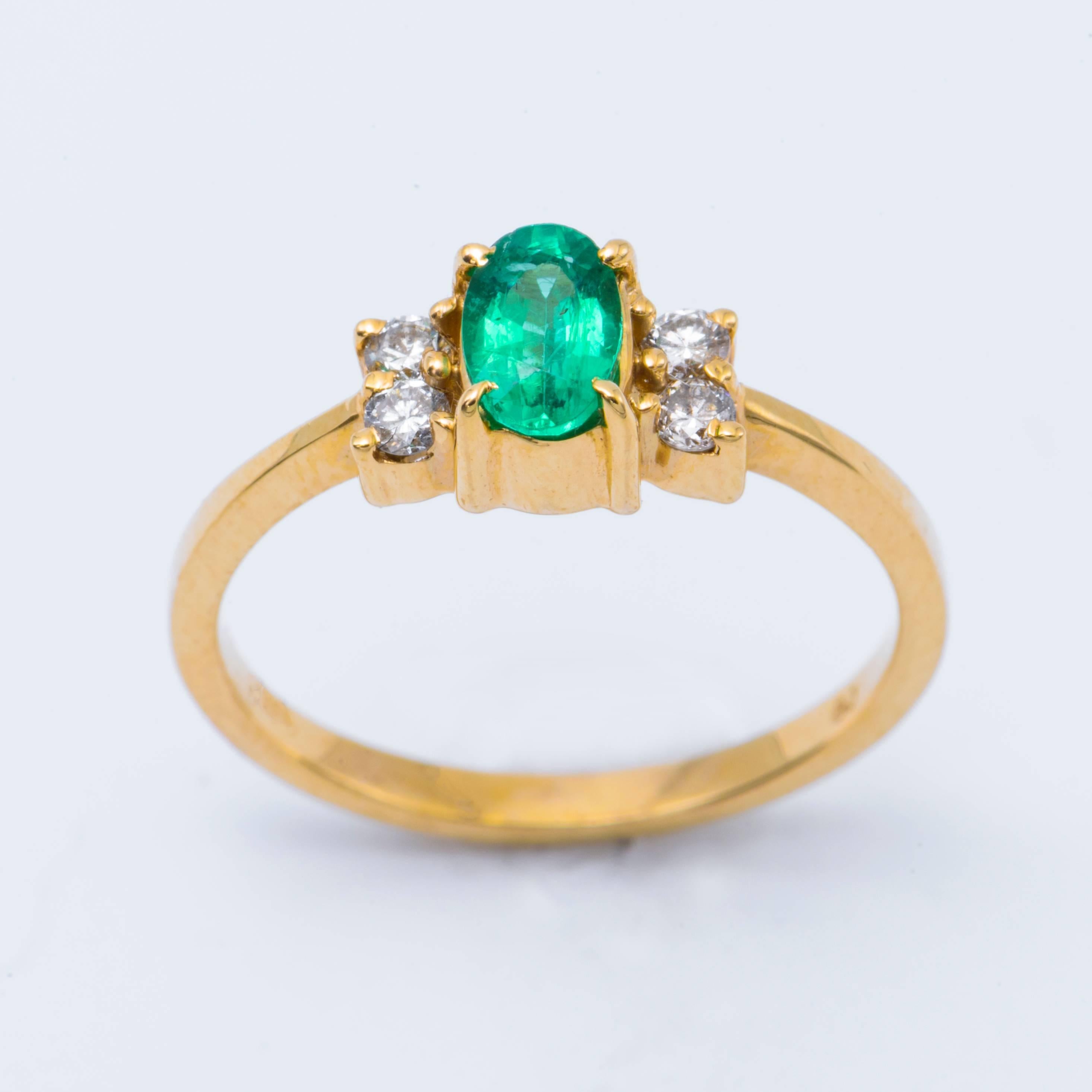 Contemporary Oval Shaped Emerald and Diamond Engagement Ring in Yellow Gold