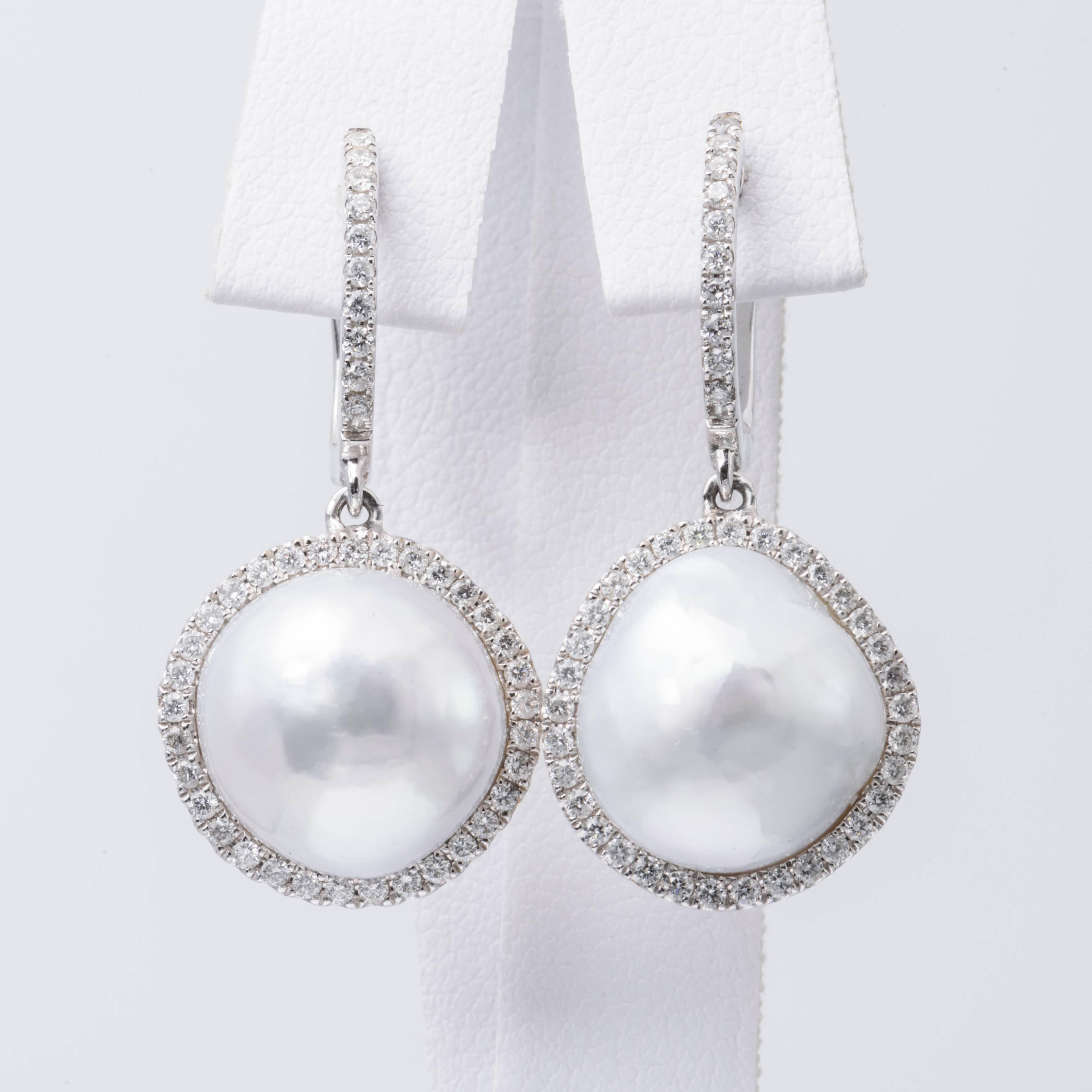 barocke Südseeperlen-Ohrringe aus 18 K Weißgold, 12-13 mm groß, flankiert von runden Brillanten mit einem Gewicht von 0,64 Karat. Perlen sind weiß mit silbernem Unterton

Passende Halskette ist erhältlich. 