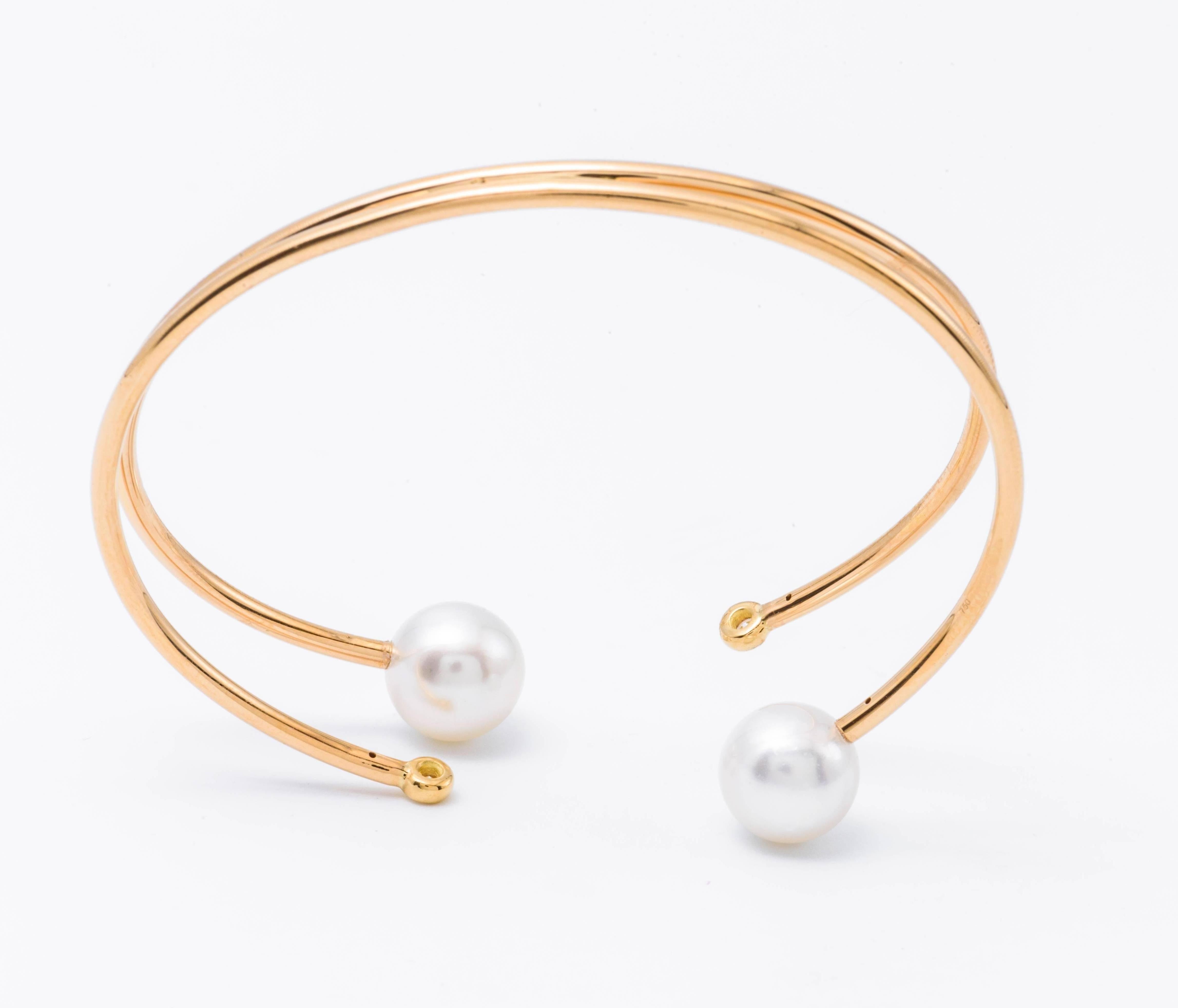 18 Karat yellow gold bangle with 2 diamonds which weights 0.12 Cts T/W and 2 South Sea pearls 9.50-10 mm each