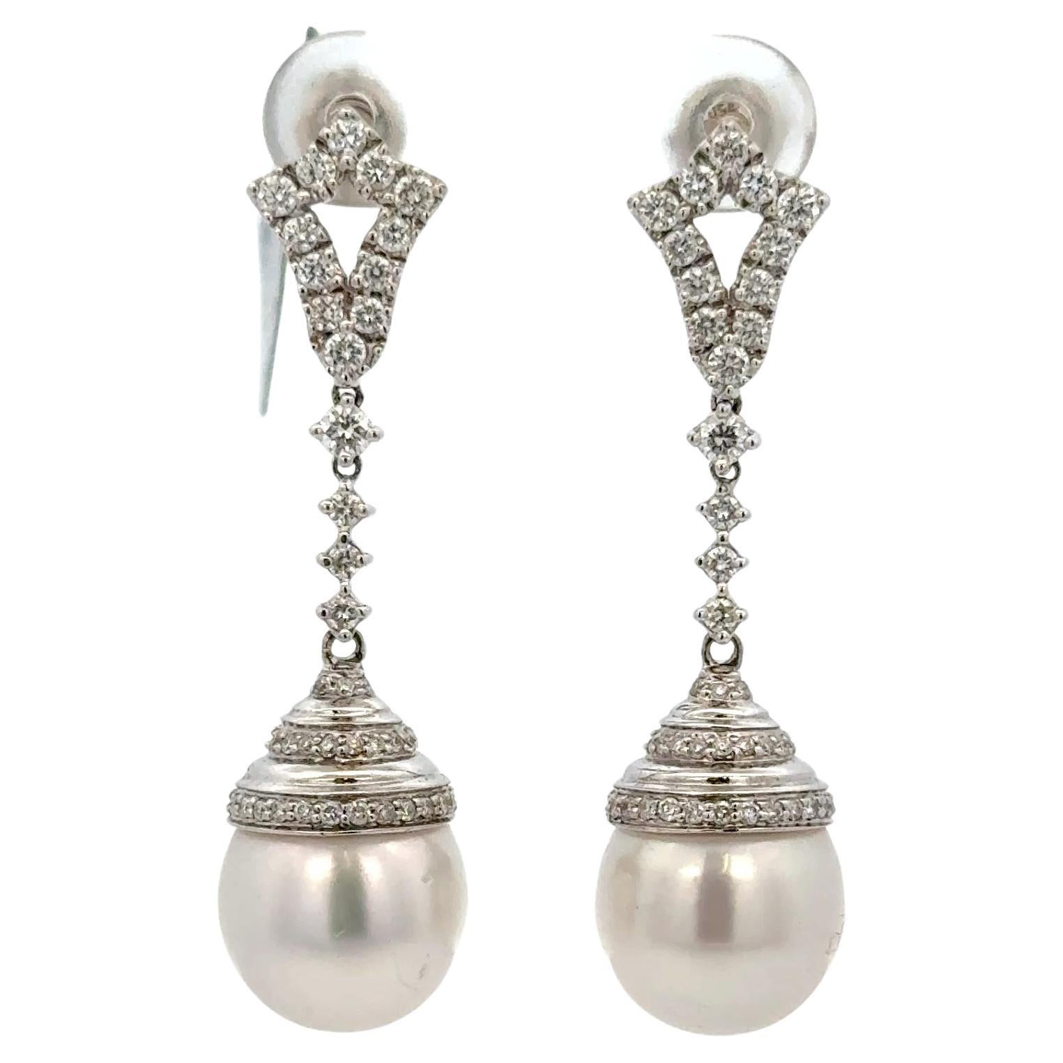 Pendientes colgantes de oro blanco de 18 quilates con dos perlas de los Mares del Sur de 11-12 mm y 82 brillantes redondos de 0,90 quilates.
