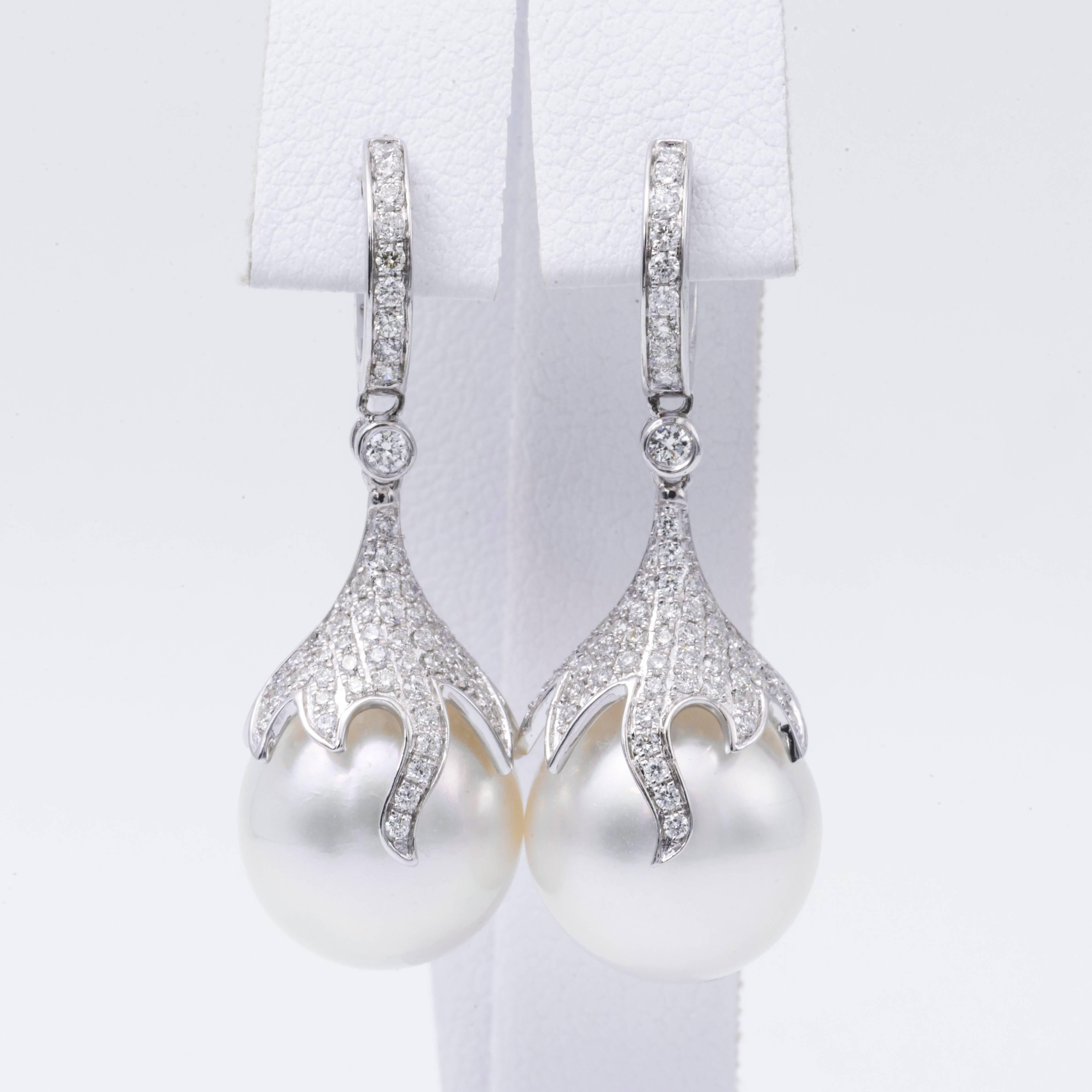 18K White gold drop earrings featuring two South Sea Pearls measuring 12-13 mm flanked with 122 round brilliants weighing 0.73 carats.

Pearl Quality AA
Luster AA, Excellent
Nacre Very Thick