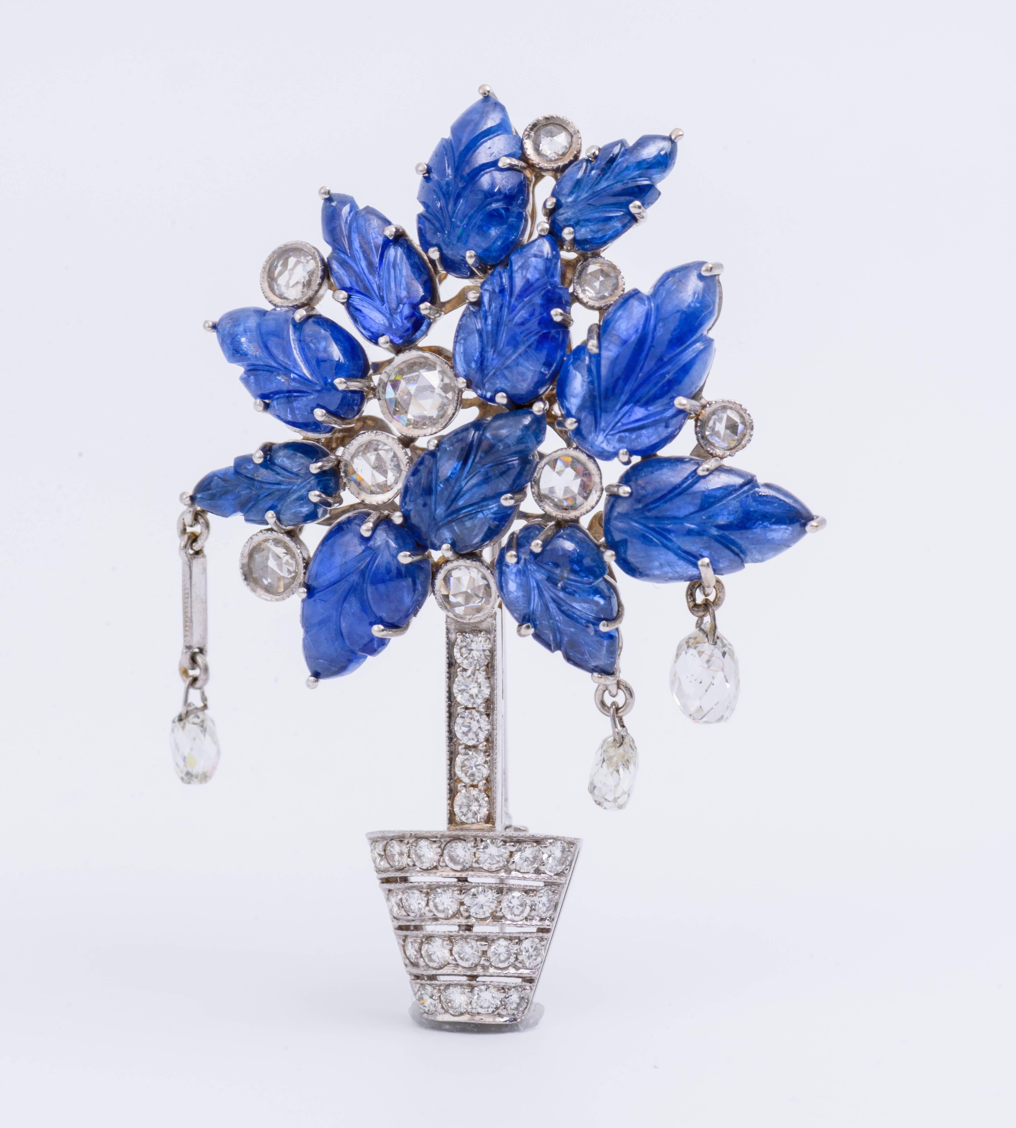 This Blue Sapphire and White Diamond pin is set in 18kt Gold and features 3 hanging Briolette and is 9.4 dwt. The accents on this piece create a beautiful representation of nature.