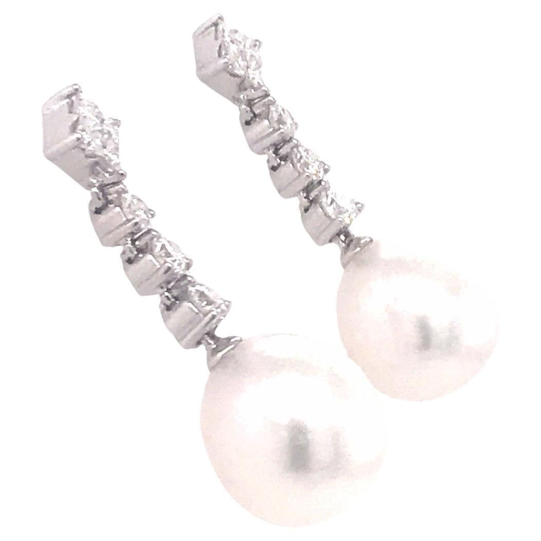 18K White gold drop earrings featuring two South Sea Pearls measuring 11-12 mm with 8 princess cut diamonds weighing 0.39 carats and 6 diamonds weighing 0.61 carats.
Color G-H
Clarity SI

Pearls can be changed to Tahitian, Pink or Golden Pearls upon