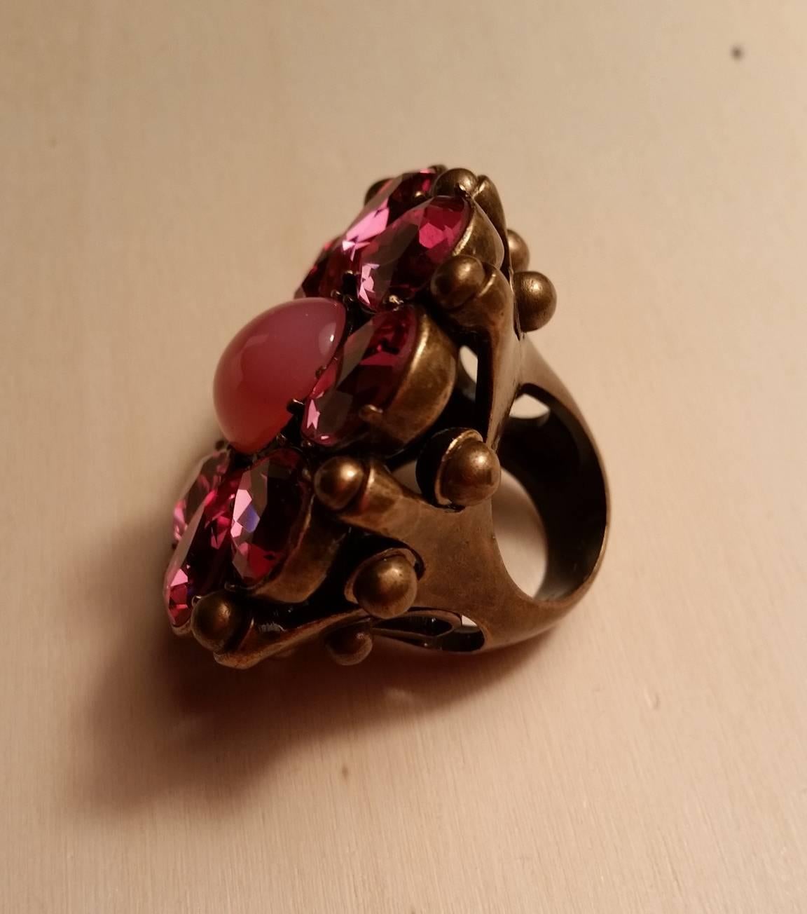 Bague de défilé haute couture baroque Christian Dior - 1980
Garni de pierres en cristal rose et d'une base en métal de couleur bronze. 
Vendu avec sa boîte.
Etat neuf.
Taille : 20.93 (US), 52 (Europe)