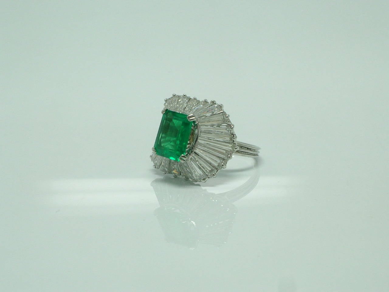 The emerald-cut colombian emerald weighing approx. 2.20ct to the tapered baguette-cut surround.
Accompanied by report dated 25 march 2015 from the Gem & Pearl Laboratory, London, stating that the emerald is of Colombian origin with evidence of