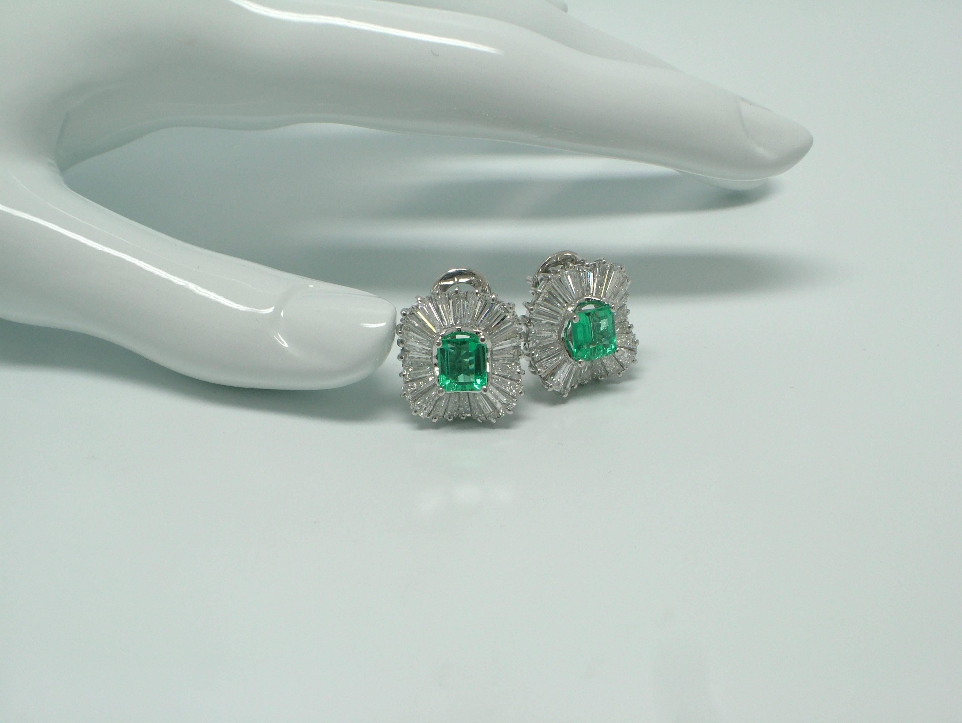 A pair of 18 karat white gold, diamond and emerald earrings.  In the center with 2 emeralds weighting 2,80ct. surrounded by tapered  baguette-cut diamonds weighing approx. 7,50ct. 
Emerald measures: 6,8x6mm
