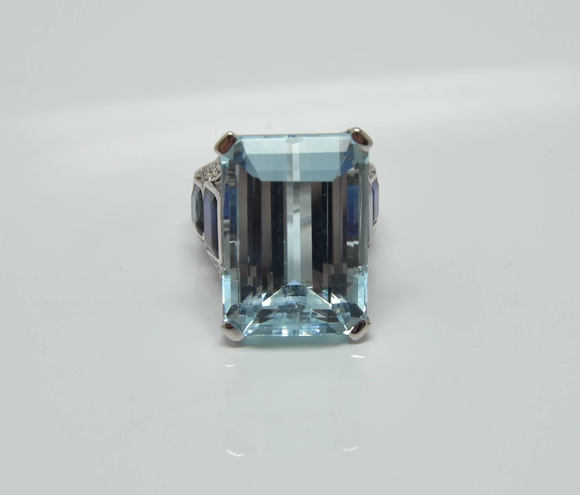 
A gorgeous 18K white gold ring. The step cut Aquamarine claw set, to the emerald cut sapphires and brilliant cut diamonds set on the shoulders.

Measurements:
Internal diameter: 17,5 mm
Size:  US 7 -7 1/4
Measurements front: 20x20 mm
The Ring sits