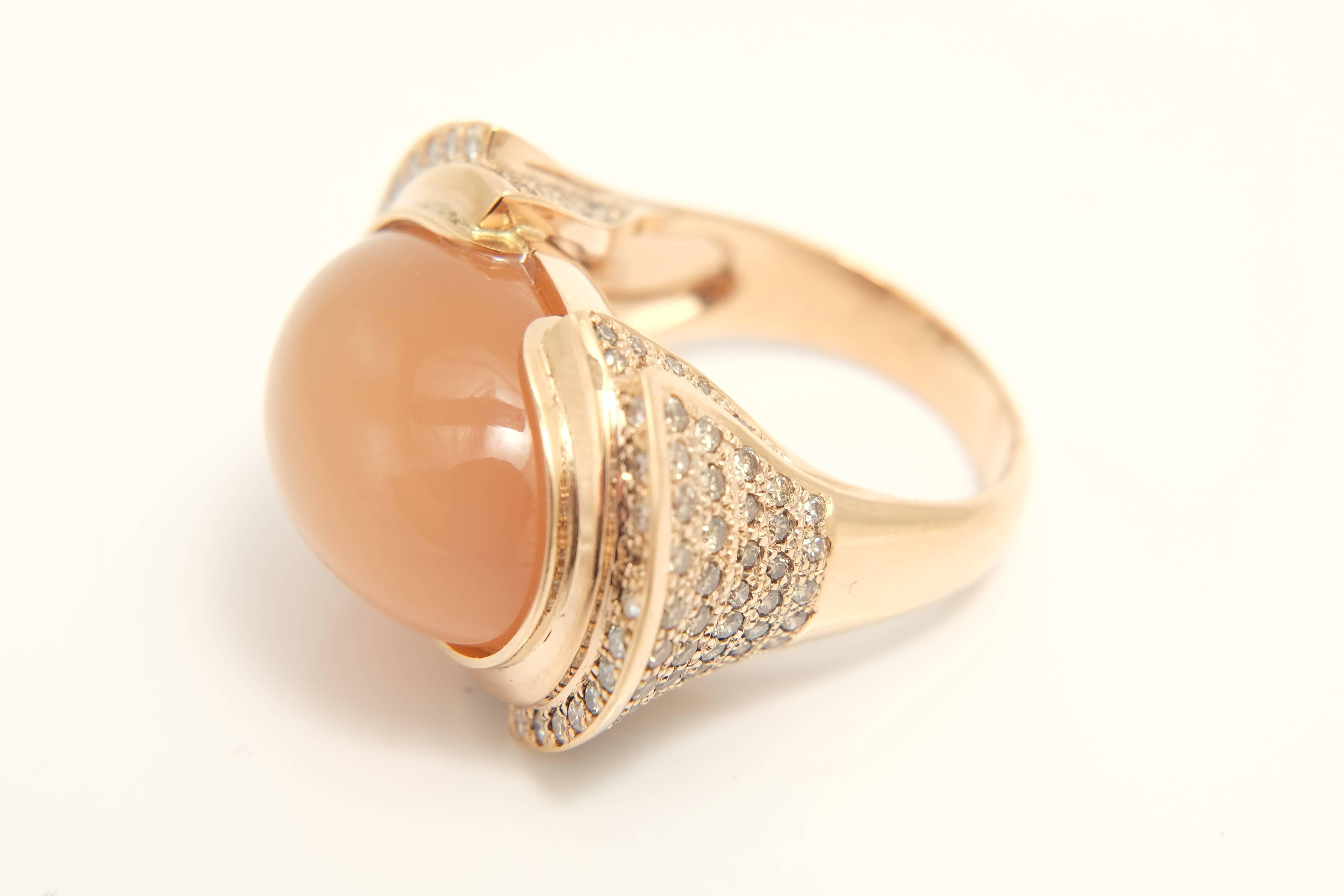 A fashionable 18k pink gold  ring featuring Oval shaped cabochon moonstone in center weighing      carats. stone is set horizontaly and surrounded by pave set Round Diamonds    totaling  carats. 

Very well made ring. 
