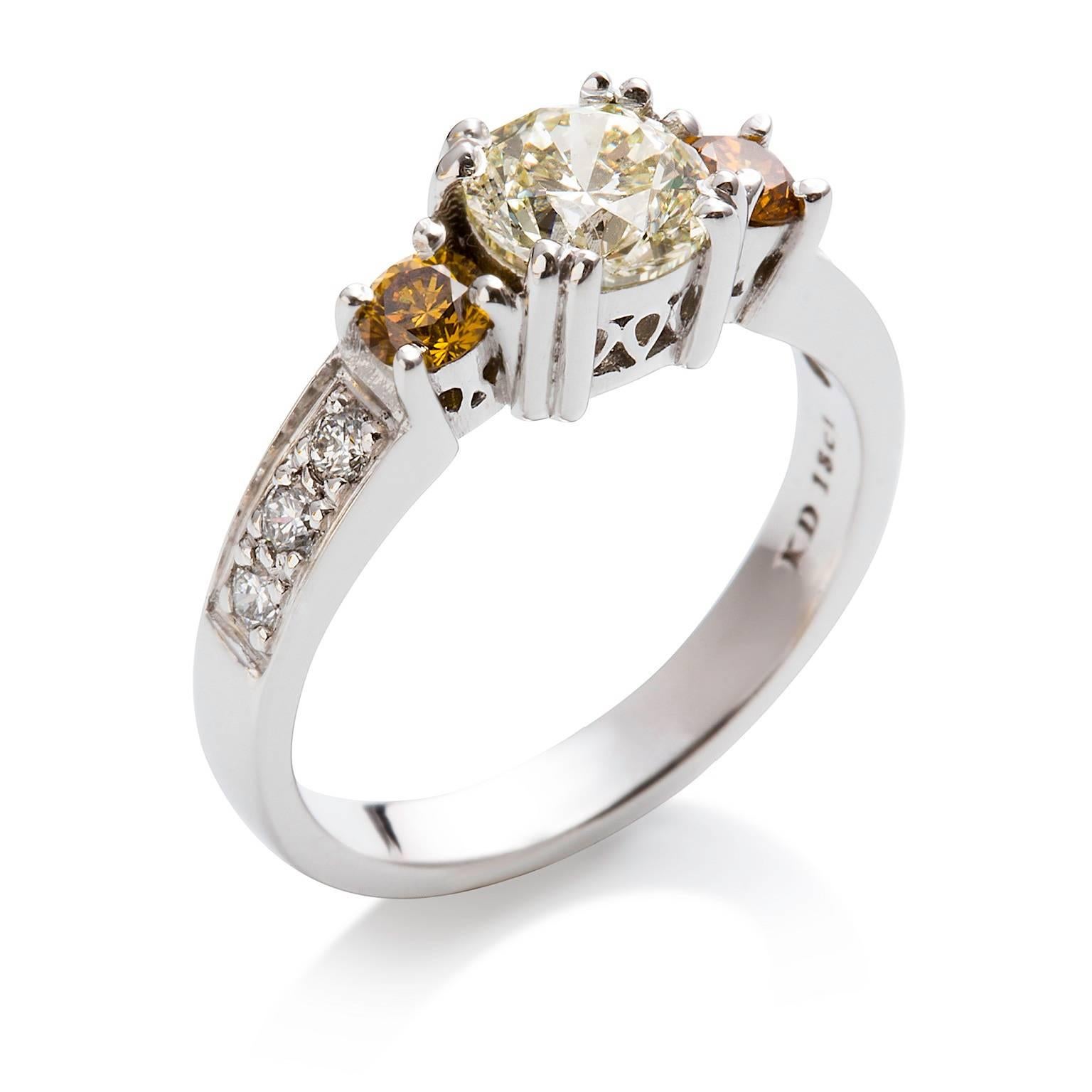 Oro & Bianca Diamante Ring

This eye-catching ring features a large white diamond which has an attractive smaller golden diamond on either side. The band is bead set with petite white diamonds also.

Round brilliant cut diamond: M colour, SI1