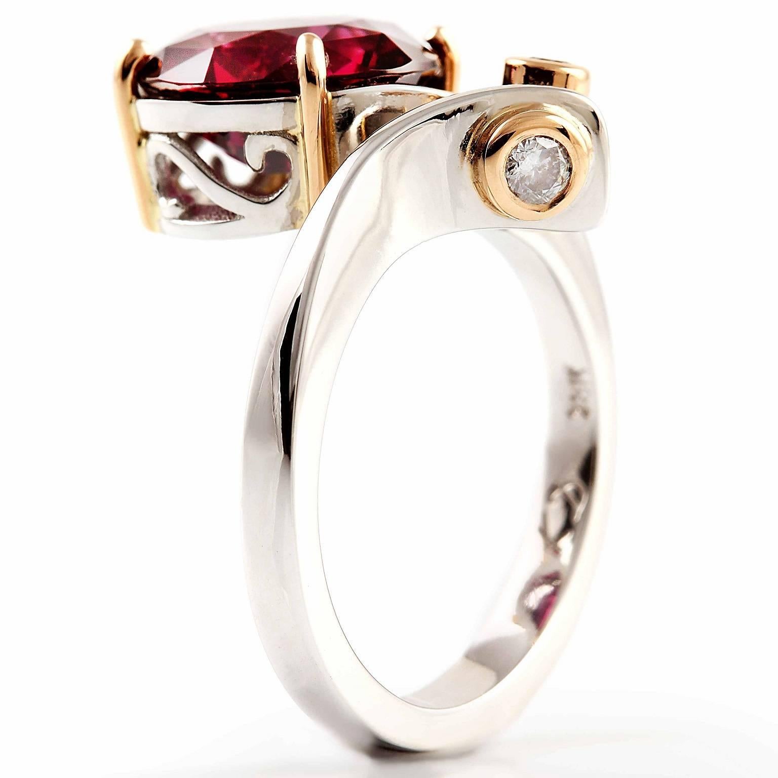 Rhodolite Ring

The stunning oval cut rhodolite garnet is set in four rose gold claws in a fancy scroll design white gold setting is diagonally complimented with two petite diamonds in rose gold chenier settings. The sweeping shoulders are curved