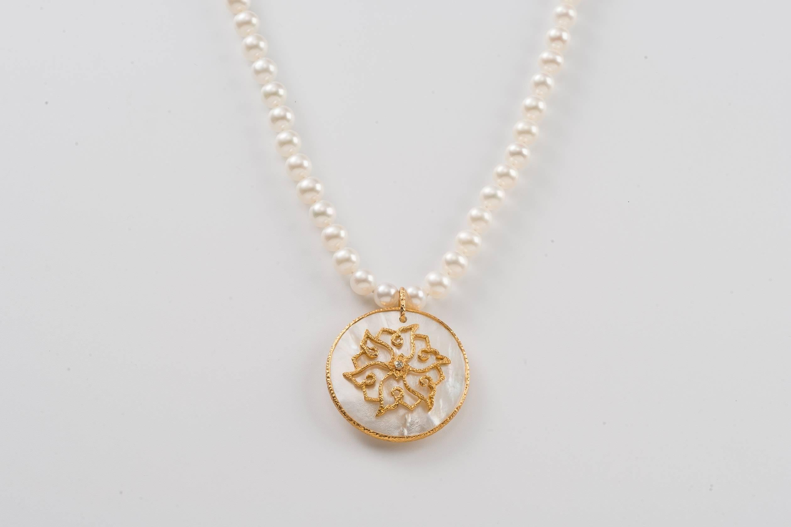 The 22.5 in L (57cm L) fresh water pearl necklace from our Heritage Collection of Chinoiserie designs, the luminous mother-of-pearl pendant is wrapped in hammered gold with a lotus motif design centered with a diamond, 1.5 in (4cm) dia. The lotus is