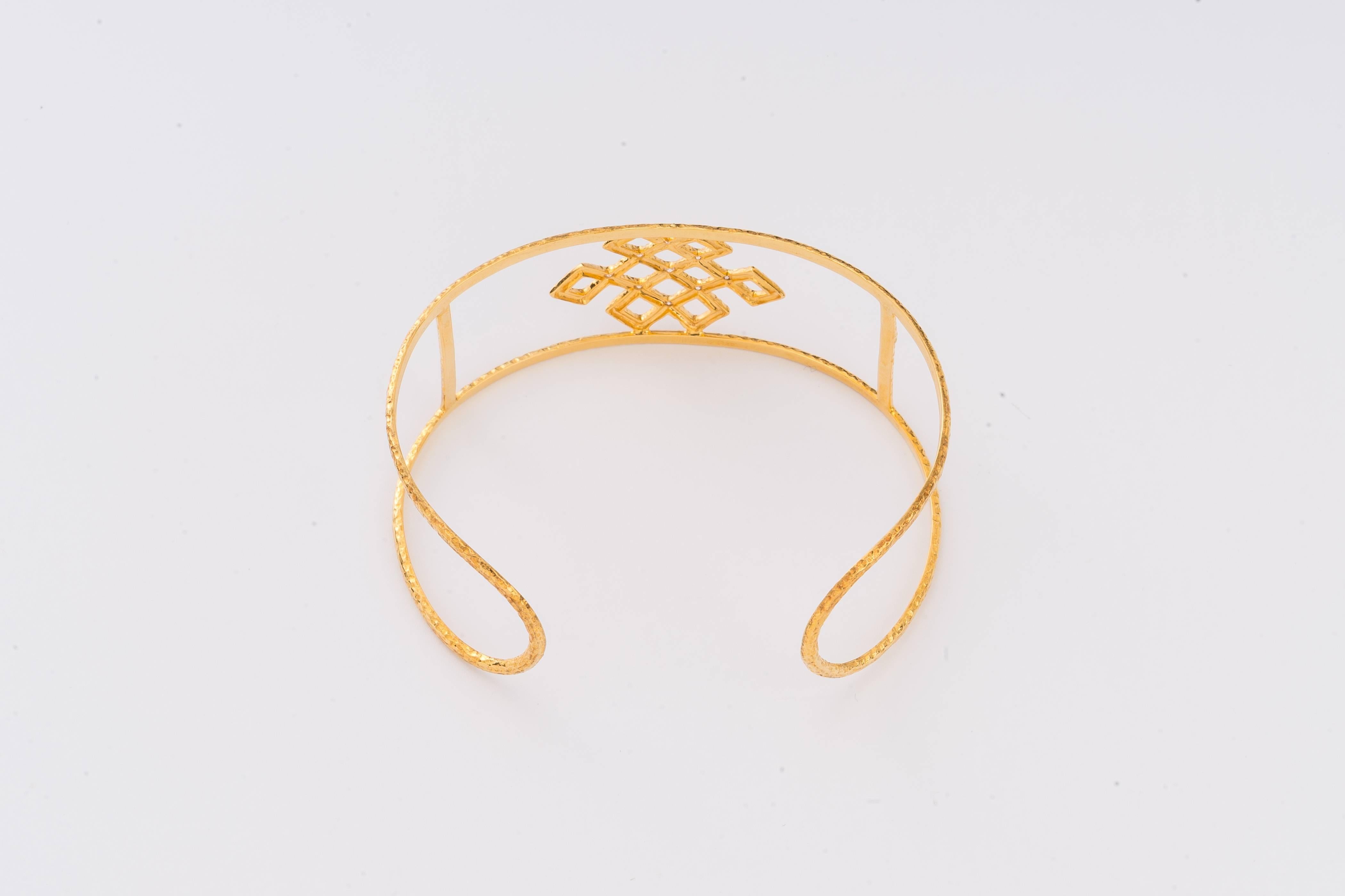 The hand-worked 18-Karat gold cuff is from our Heritage Collection of Chinoiserie designs.  height 1 inch (2.5cmH), hand-hammered and centered with an openwork endless knot (eternity, intertwining of wisdom & compassion symbol) decorated with