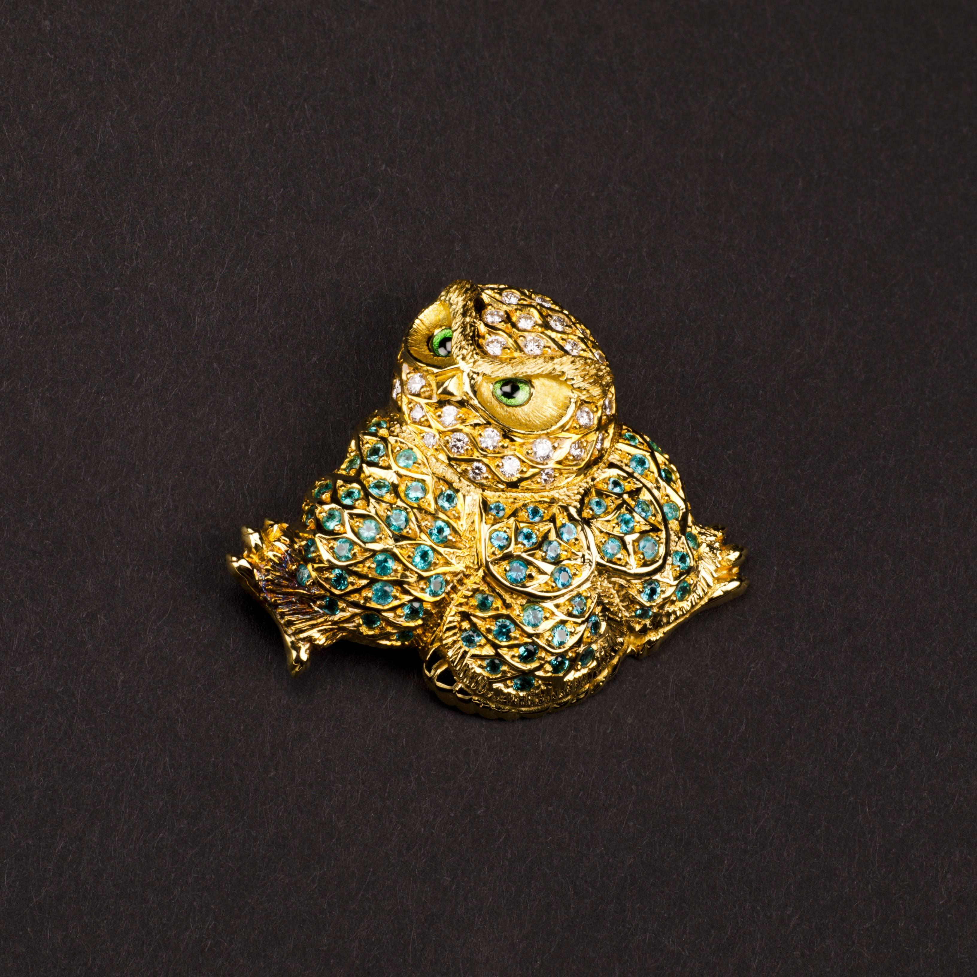 An intricate and highly decorative 18ct yellow gold owl brooch encrusted with precious Paraiba tourmalines with diamonds.

This fabulously regal and wise looking owl is an exclusive Henn design collaboration with master gemstone carver Alfred
