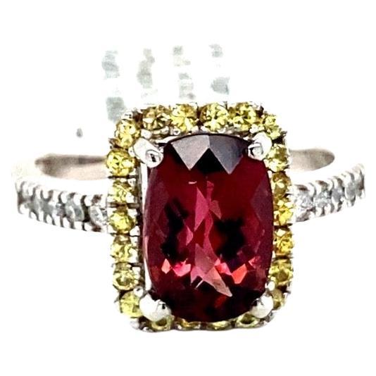 This ring has a 2.43 carat Oval Cut Tourmaline and is surrounded by 22 Yellow Sapphires that weigh 0.44 Carats as well as 10 Round Cut Diamonds that weigh 0.19 Carats (Clarity: SI, Color: F) The total carat weight of this ring is 3.06 Carats. 

This
