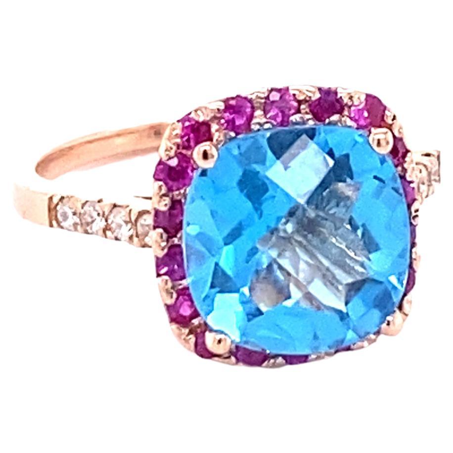 Beautiful and Unique to say the Least! 

This Ring has a magnificent Cushion Cut Blue Topaz that weighs 3.97 carats and is surrounded by 18 Round Cut Pink Sapphires that weigh 0.39 carats and 8 Round Cut Diamonds along the shank that weigh 0.15
