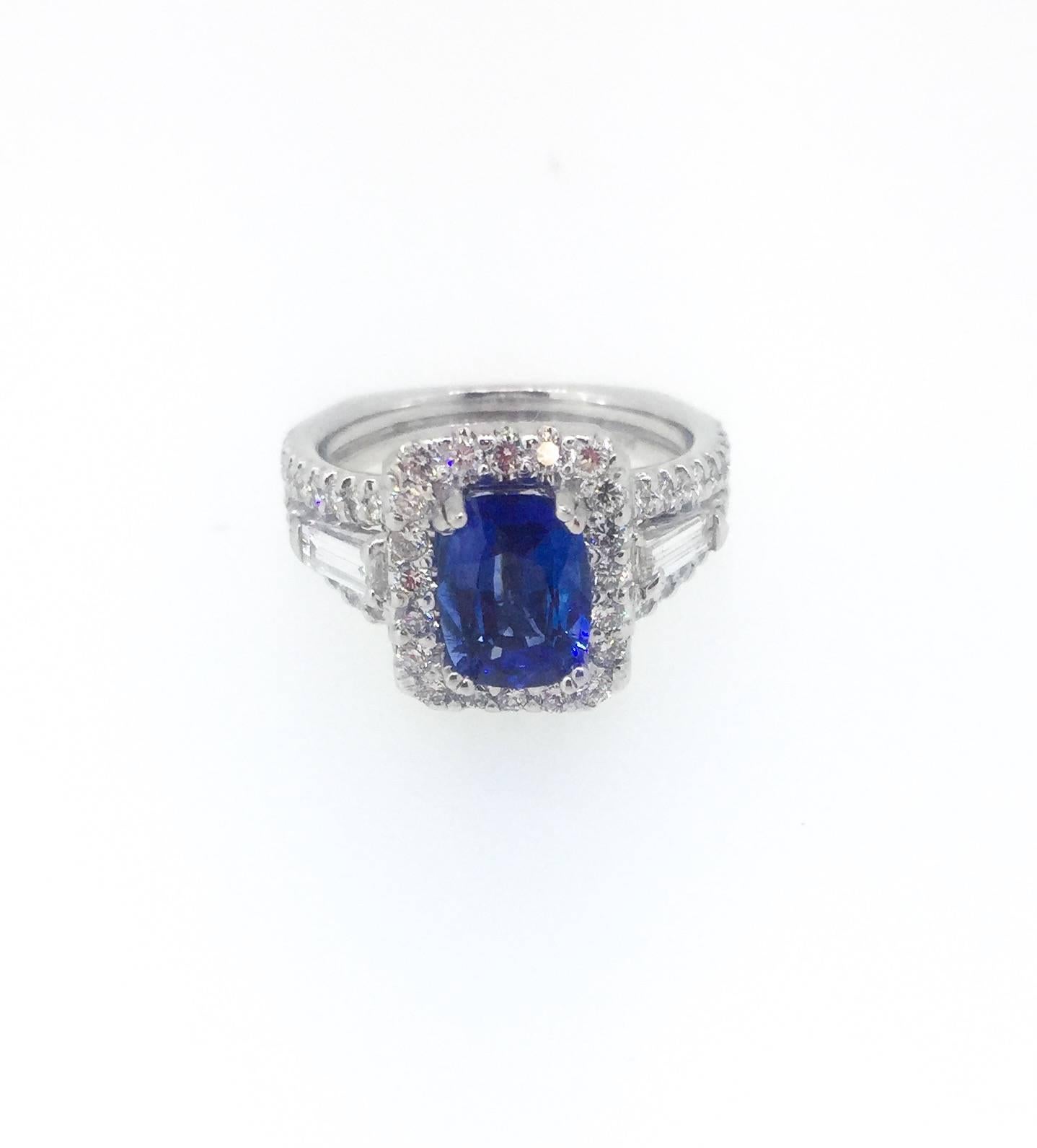 This 14K White Gold Ring has a Blue Sapphire in the center weighing 1.64 carats surrounded by 56 Round Brilliant Cut Diamonds that weigh 0.75 carats and 2 Baguette Cut Diamonds that weight 0.20 carats.  This ring is GIA Certified - Cert #