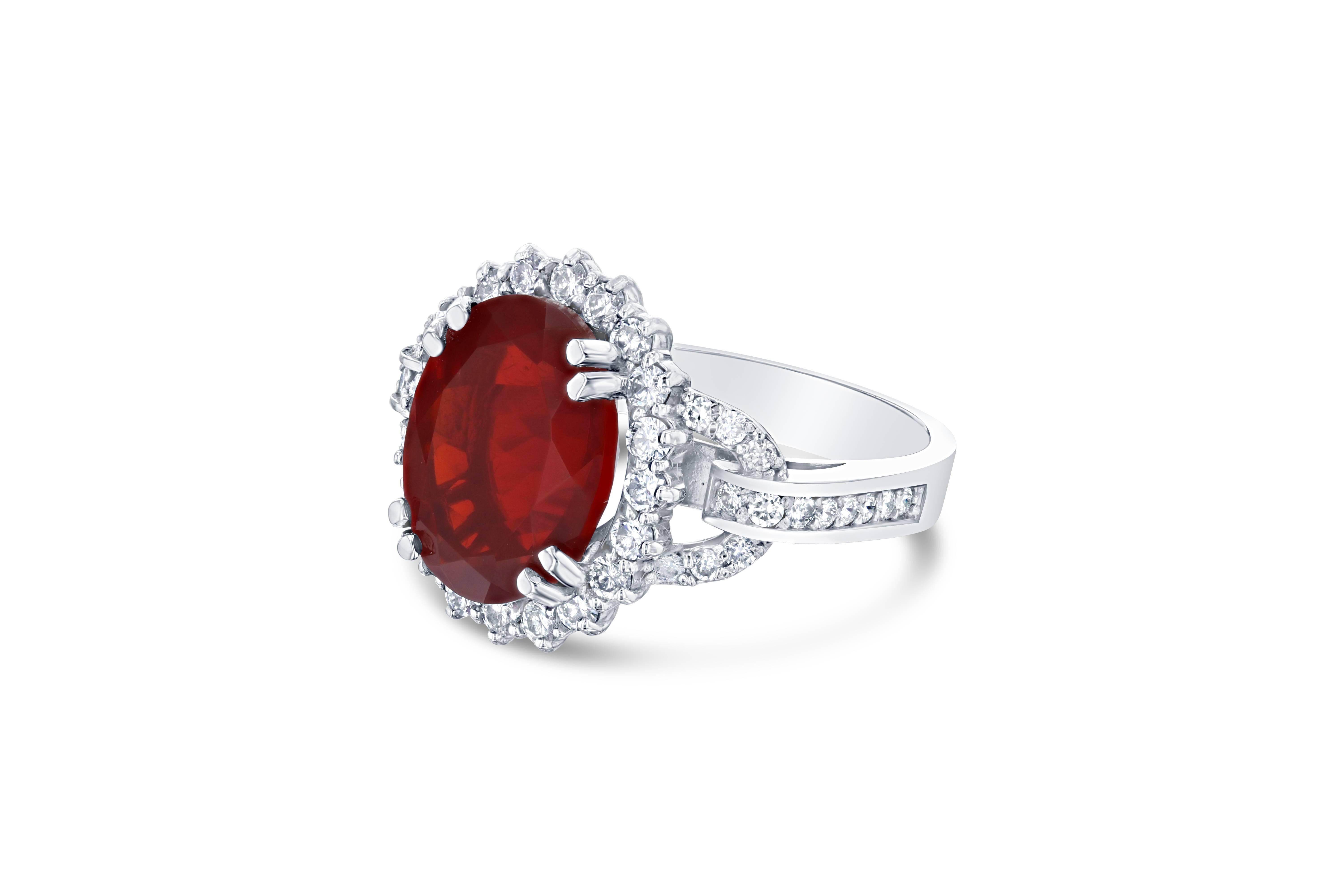This ring has a 4.61 carat Fire Opal in the center of the ring and is surrounded by 48 Round Brilliant Cut Diamonds that weigh a total of 0.89 carat.  The Clarity is a VS and the Color is H.  The ring is casted in 14K White Gold weighs approximately