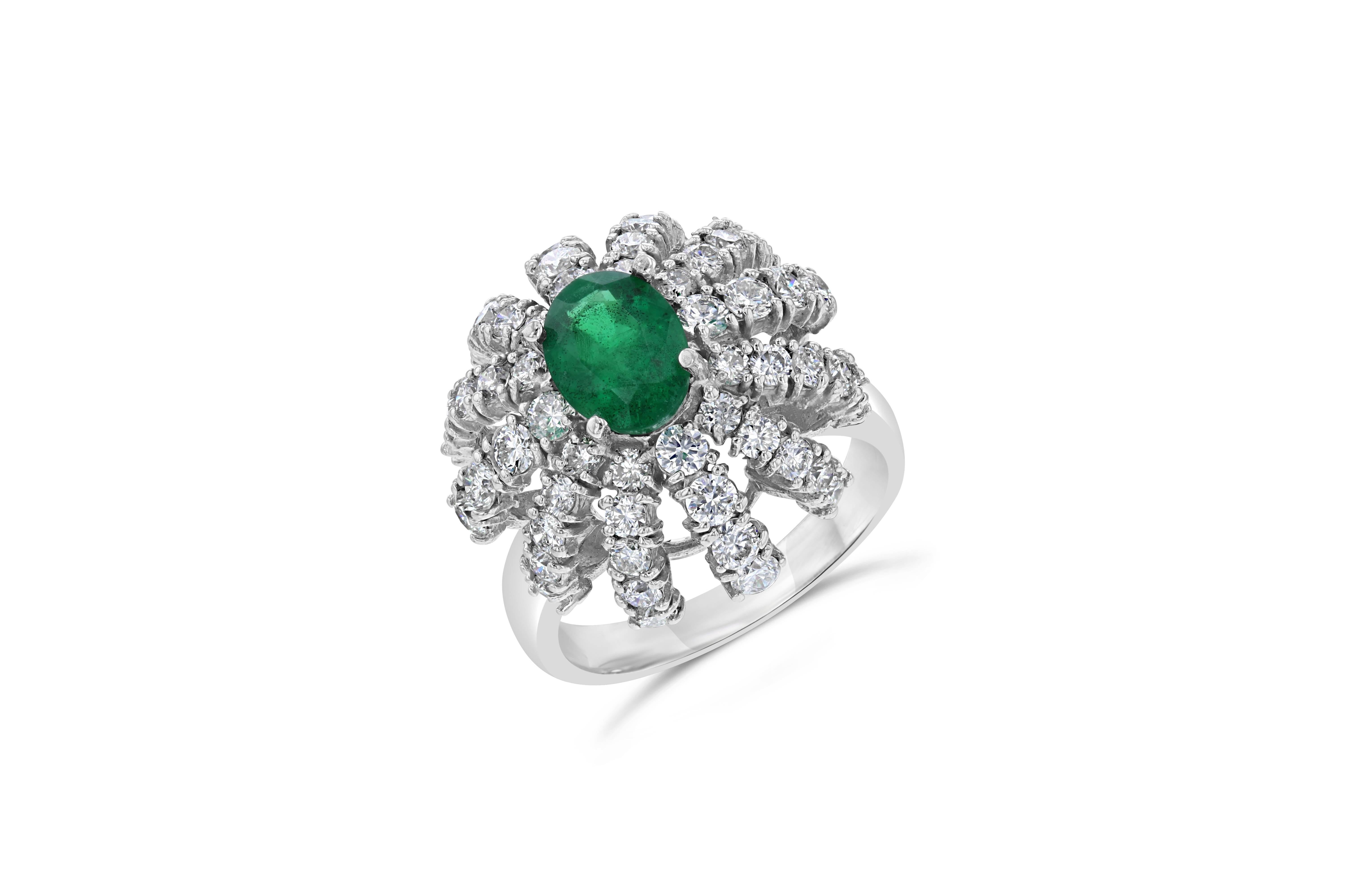 Inspiring vintage beauty with a modern flair! 
This ring has a natural Emerald that is 1.21 Carats surrounded by a falling dome of Round Cut Diamonds weighing 1.77 Carats. It is set in 14K White Gold and weighs 6.5 grams. The ring is a size 6 and