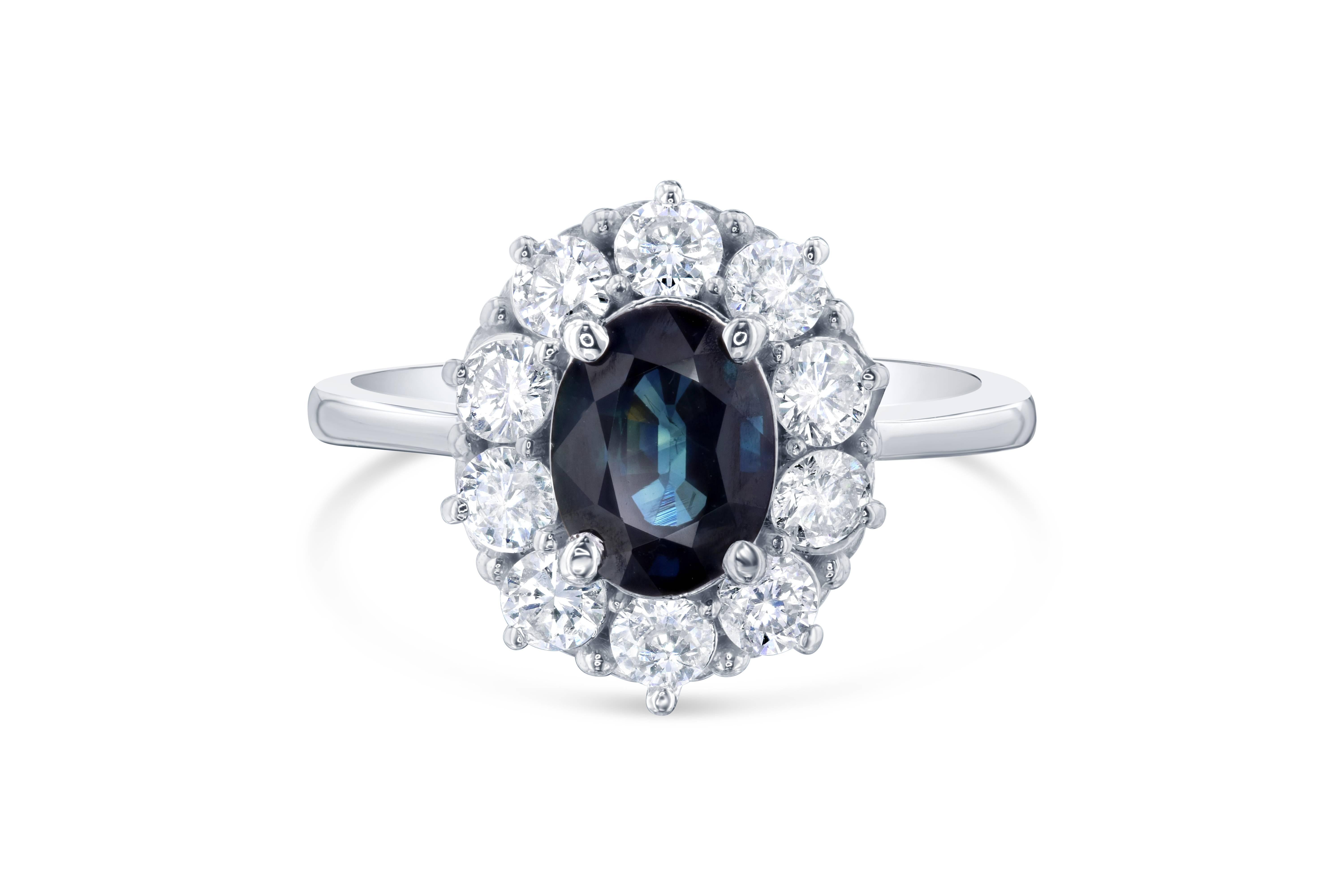 This ring is a classic beauty! The center is a 1.87 Carat Blue Sapphire surrounded by 10 Round Cut Diamonds weighing 0.87 Carats. It is set in 14K White Gold and is 4.0 grams. The Total Carat Weight of the ring is 2.74 Carats. The ring size is 7,