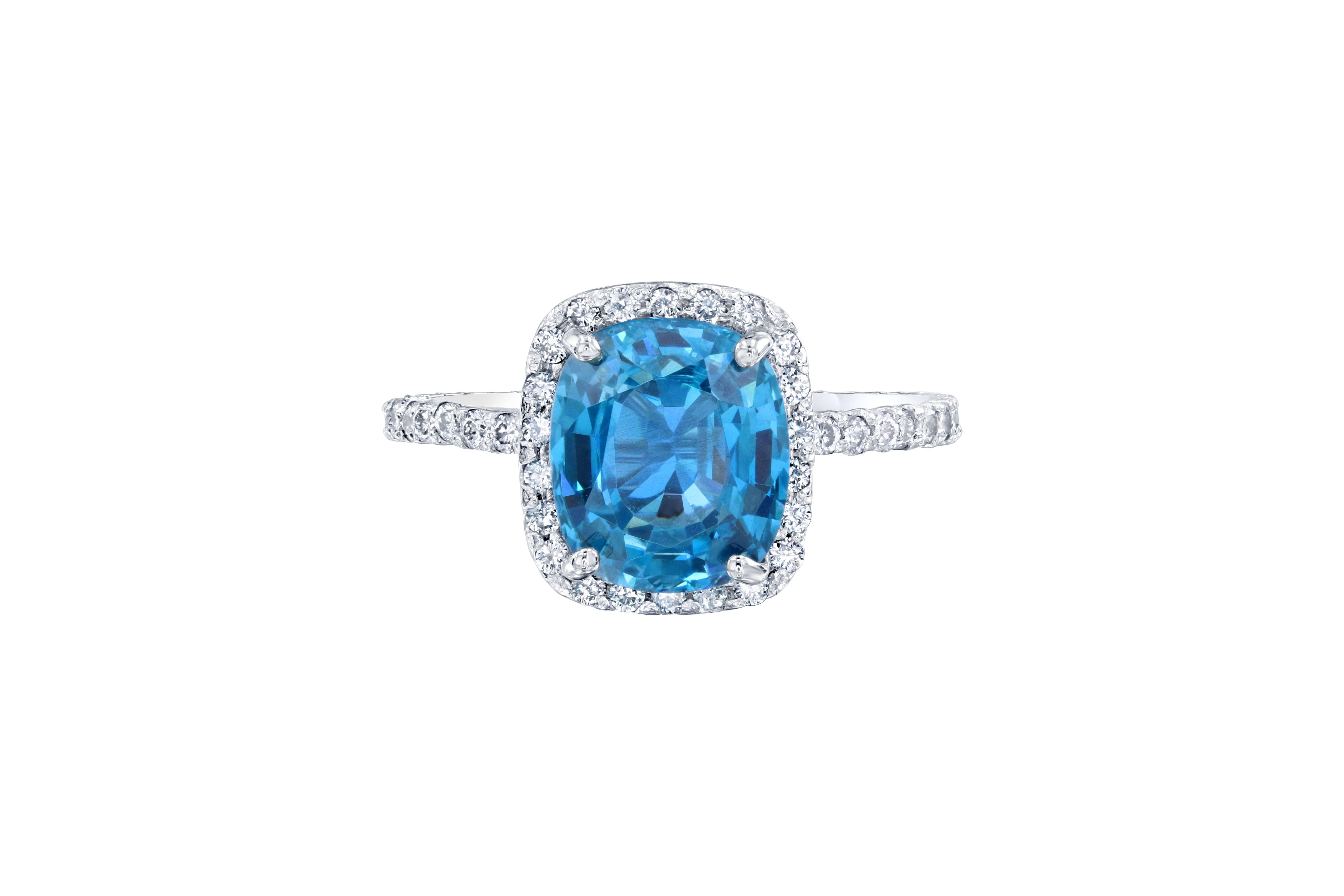 Dieser wunderschöne Halo-Ring hat einen blauen Zirkon von 3,73 Karat, der in der Mitte des Rings gefasst ist. Ein Blauer Zirkon ist ein Naturstein, der in Vietnam abgebaut wird. Der Ring ist mit 54 Diamanten im Brillantschliff mit einem Gewicht von