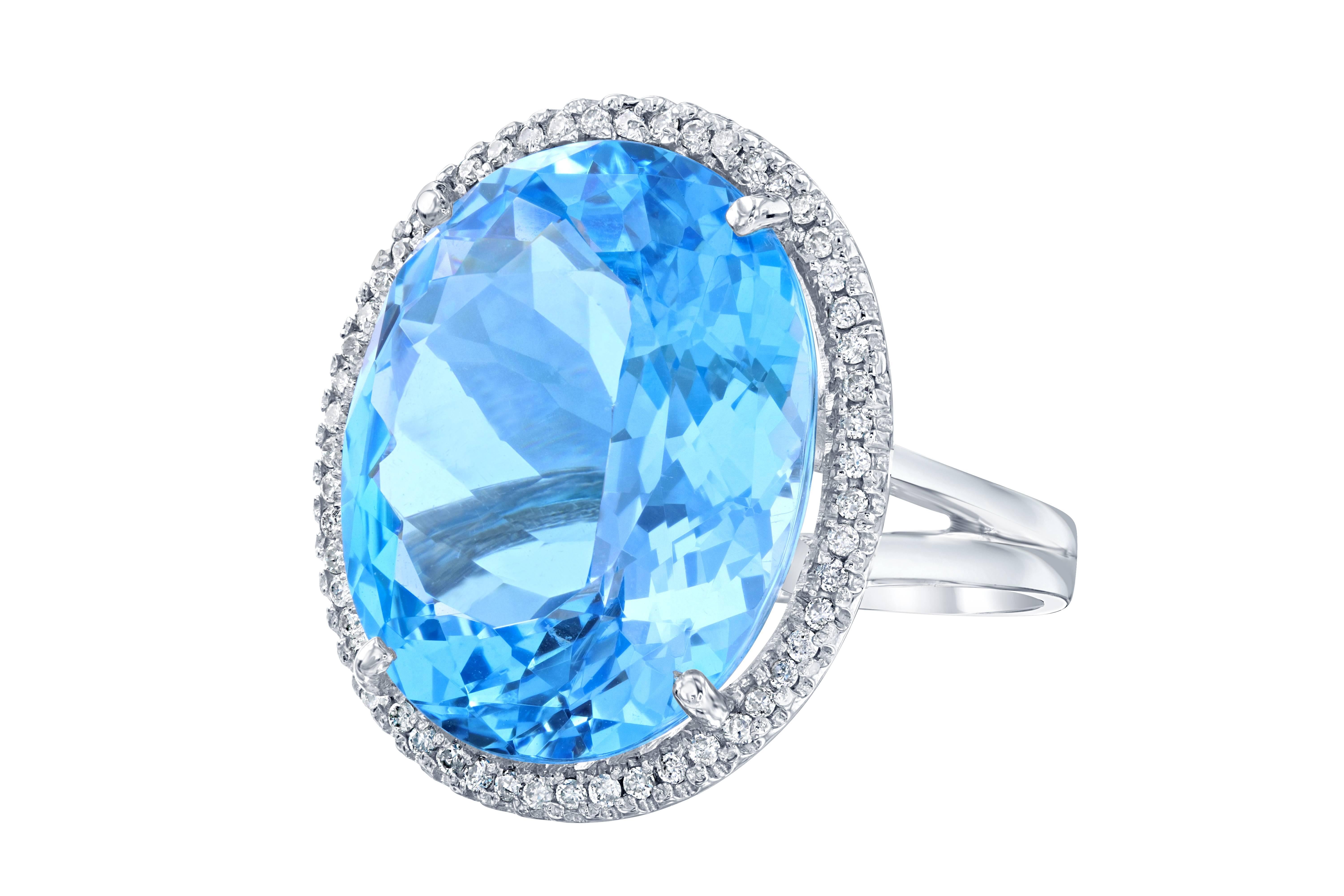 A true statement piece!  This stunning ring has a huge Oval cut Blue Topaz that weighs 29.49 carats and is surrounded by a halo of  54 Round Cut Diamonds that weigh 0.34 carat (Clarity: SI2, Color: F). The ring is made in 14K White Gold and weighs
