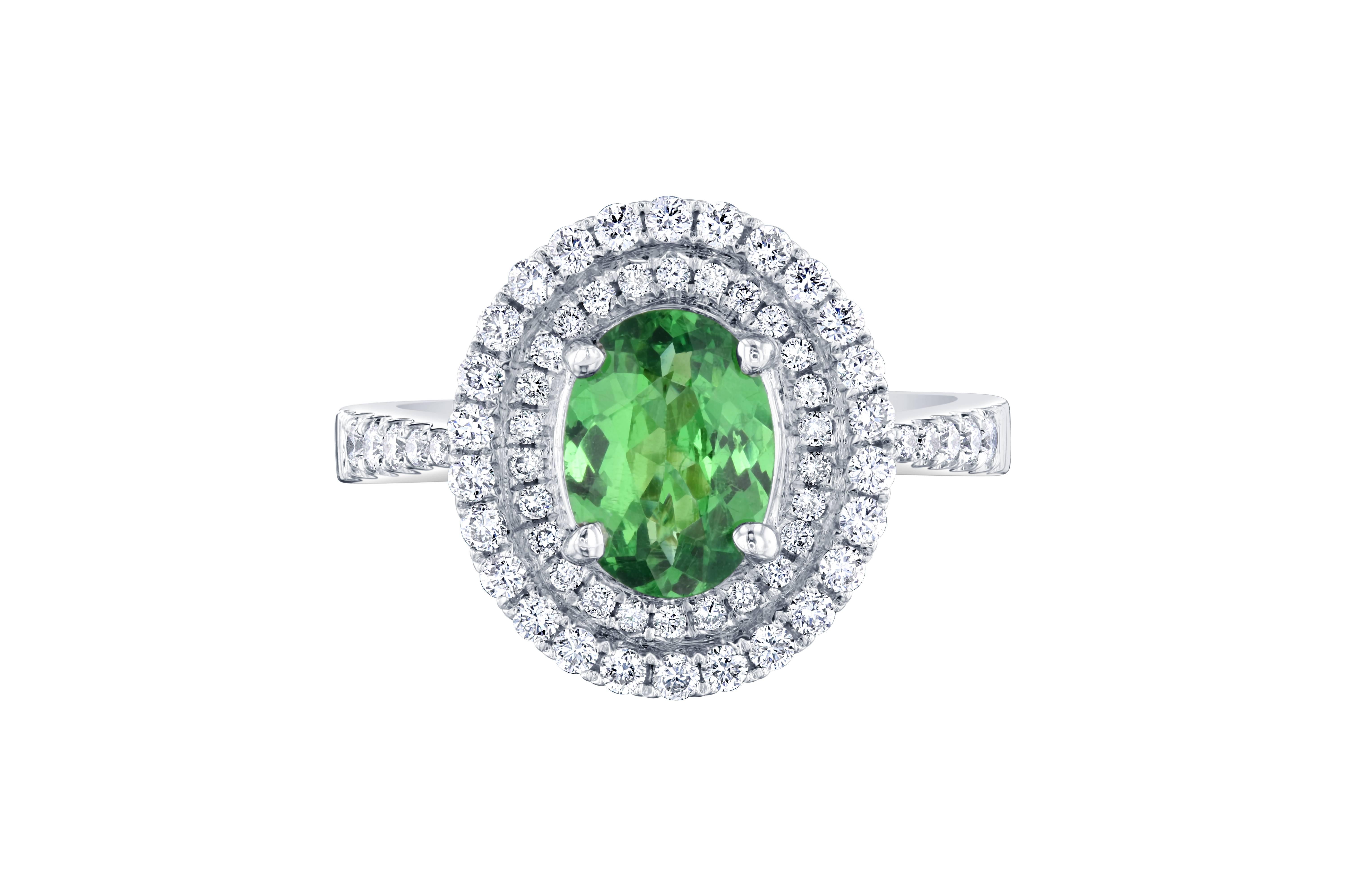 Stunning double halo setting with an Oval cut Tsavorite.   This ring has an Oval cut Tsavorite in the center of the ring which weighs 1.36 carats and is surrounded by a double halo of 62 Round Cut Diamonds that weigh 0.54 carat.  The total weight of
