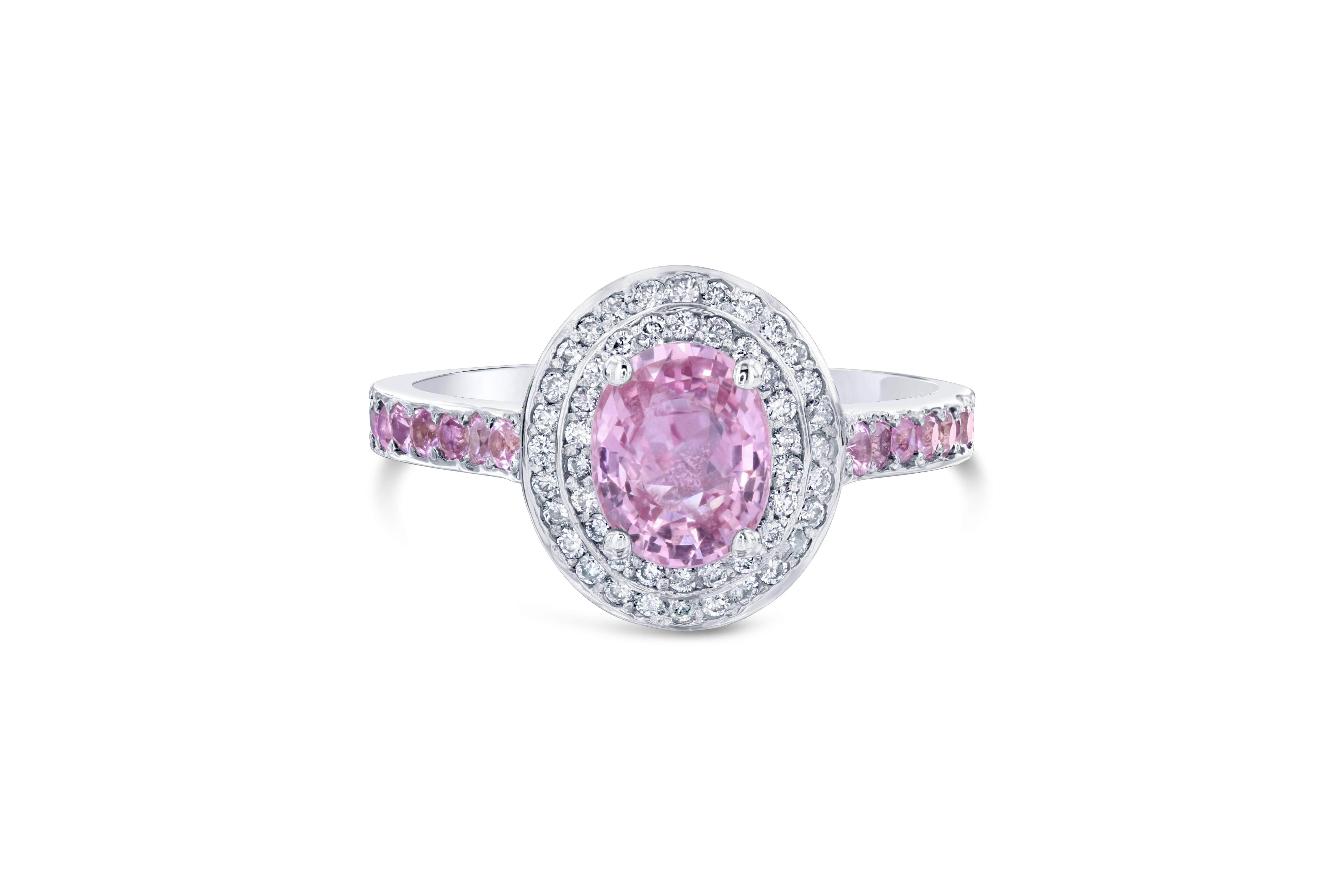 Stunning Pink Sapphire Diamond Ring with a unique choice of stone placement! Can be a very unique engagement ring! 
The center Oval Cut Pink Sapphire is 1.50 Carats surrounded by a double halo of 50 Round Cut Diamonds weighing 0.25 Carats. The shank