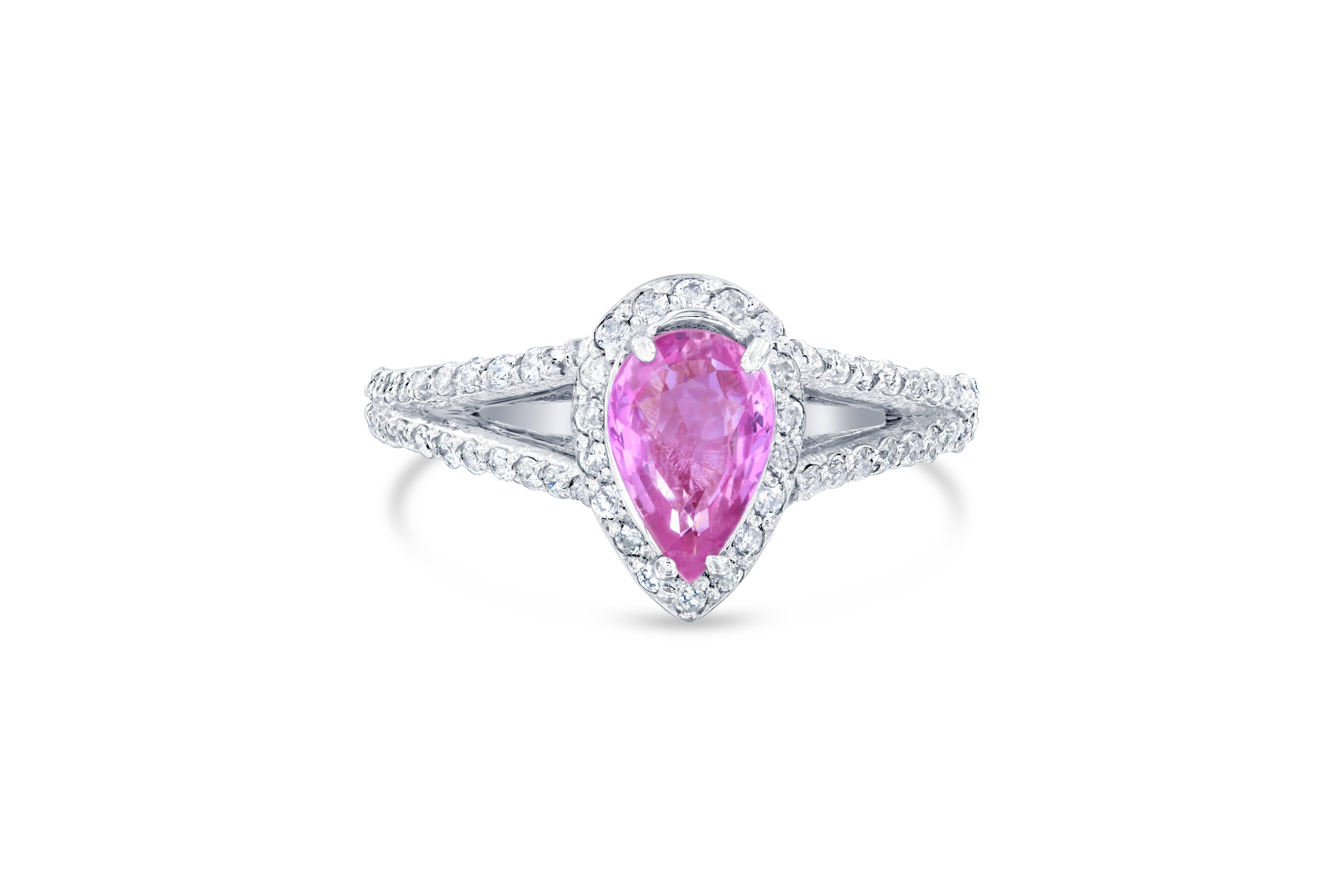 Gorgeous Pink Sapphire Diamond Ring with a beautiful setting! Can be a very unique Engagement Ring or Cocktail Ring! 
The center Pear Cut Pink Sapphire is 1.11 Carats surrounded by a halo of 40 Round Cut Diamonds weighing 0.50 Carats. The ring has a